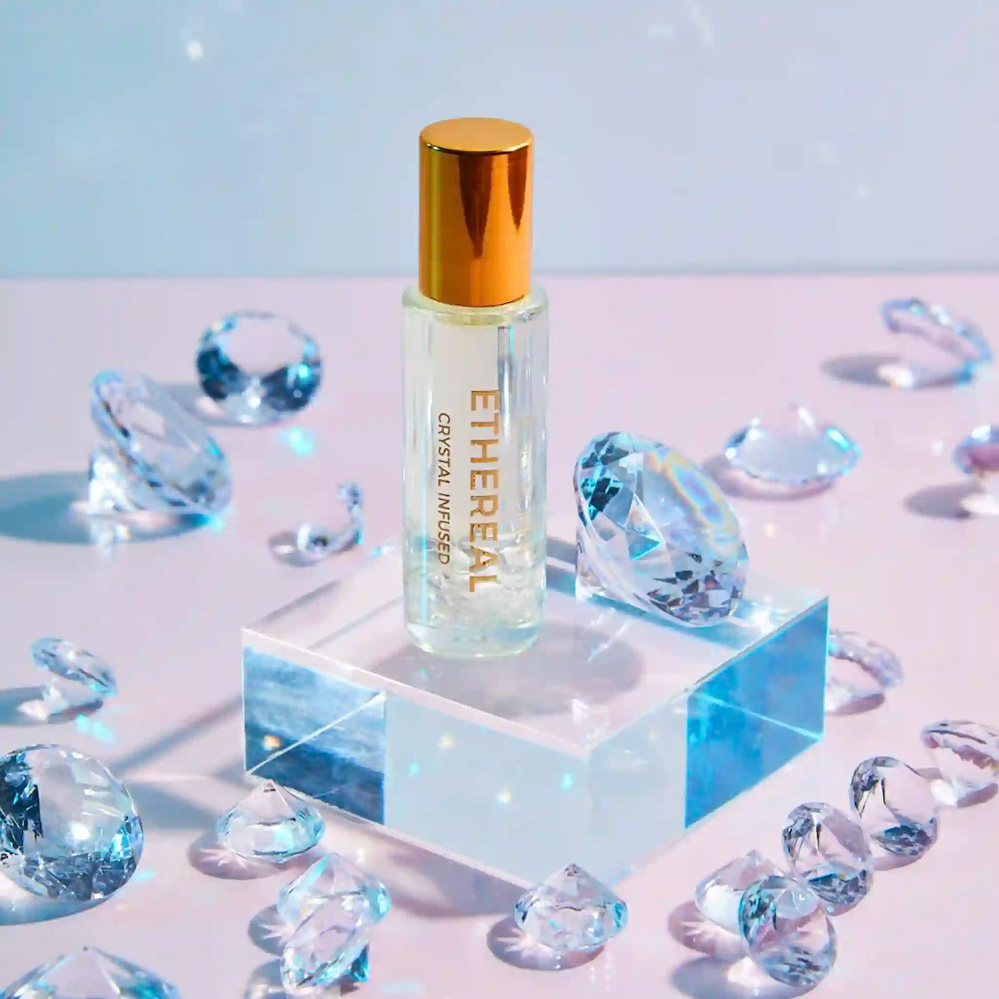 Ethereal Crystal Essence bottle surrounded by crystal-like objects on a reflective surface with a soft blue background.