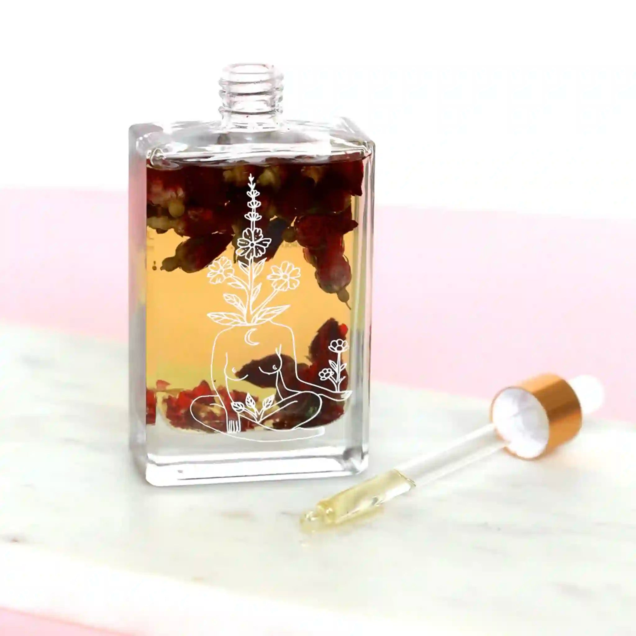 Clear glass bottle with artistic design and dropper on a light background