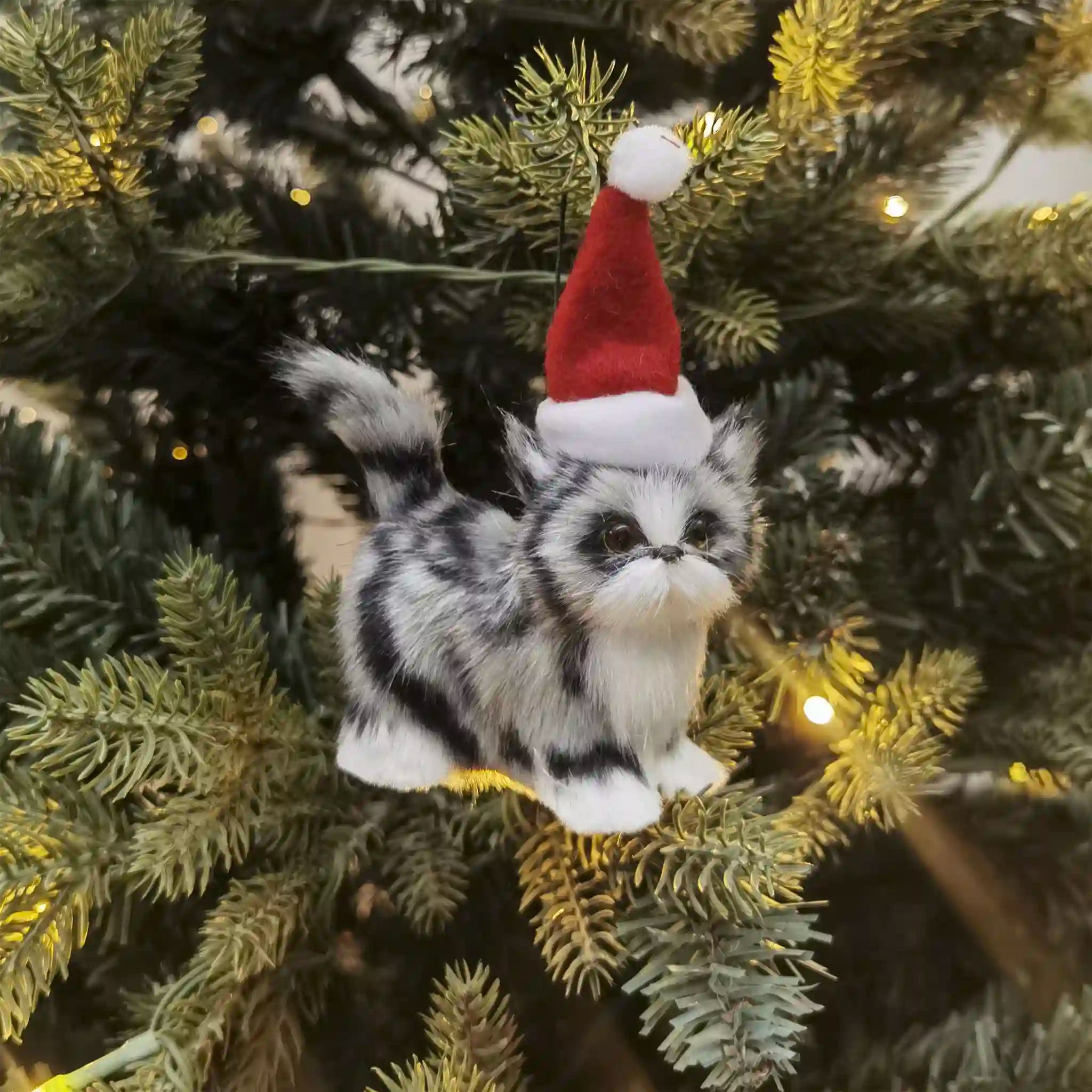 Plush cat toy with a Santa hat on a Christmas tree