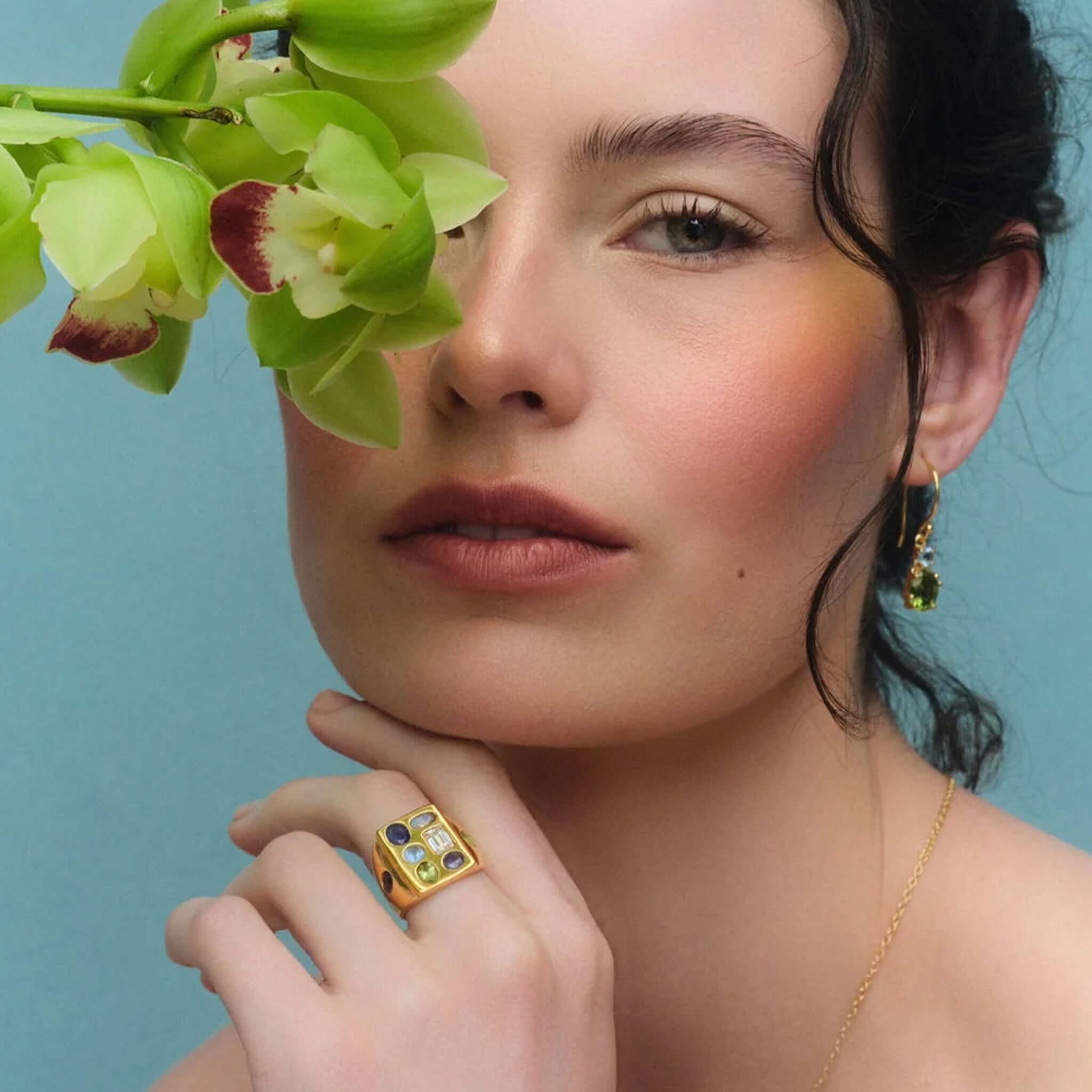Cathy Pope Elements Collection Gold Ring - Water worn by a model, showcasing vibrant stones and gold on a blue background.