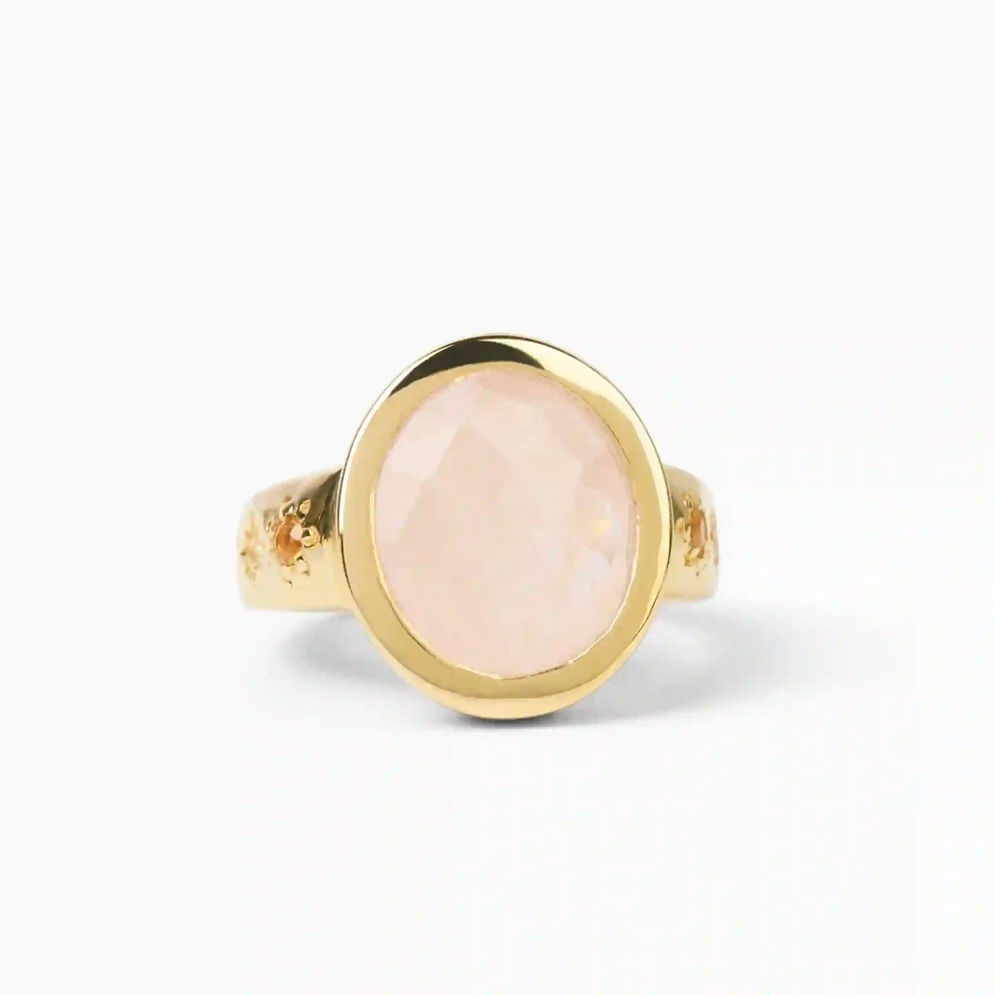 Gold ring with a pink stone on a white background