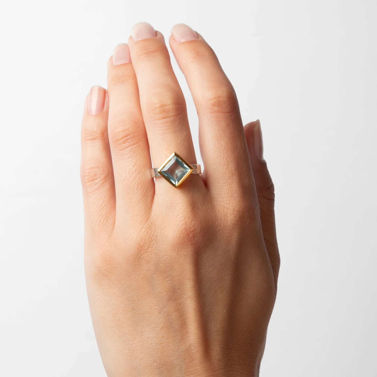 Cathy Pope Oracle Gold & Silver Ring - Blue Topaz worn on hand showcasing the faceted blue topaz and gold vermeil setting.