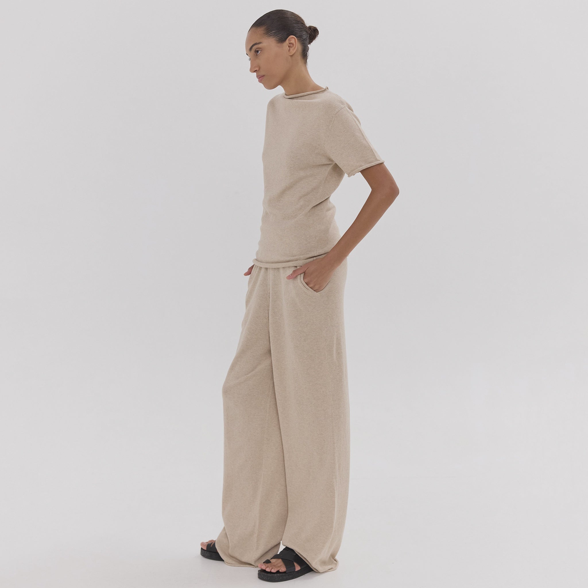 Person wearing a beige outfit on a plain background
