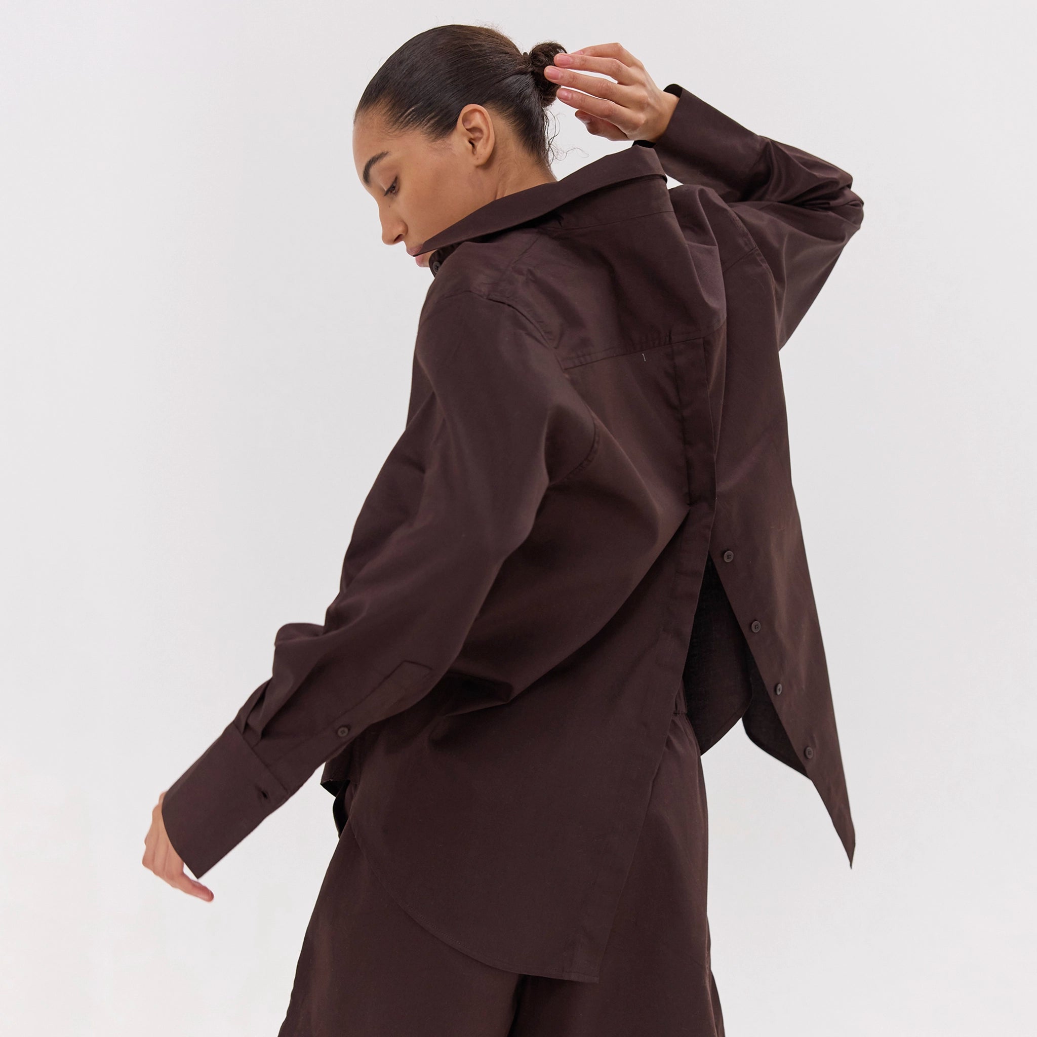 Person wearing a brown outfit against a white background