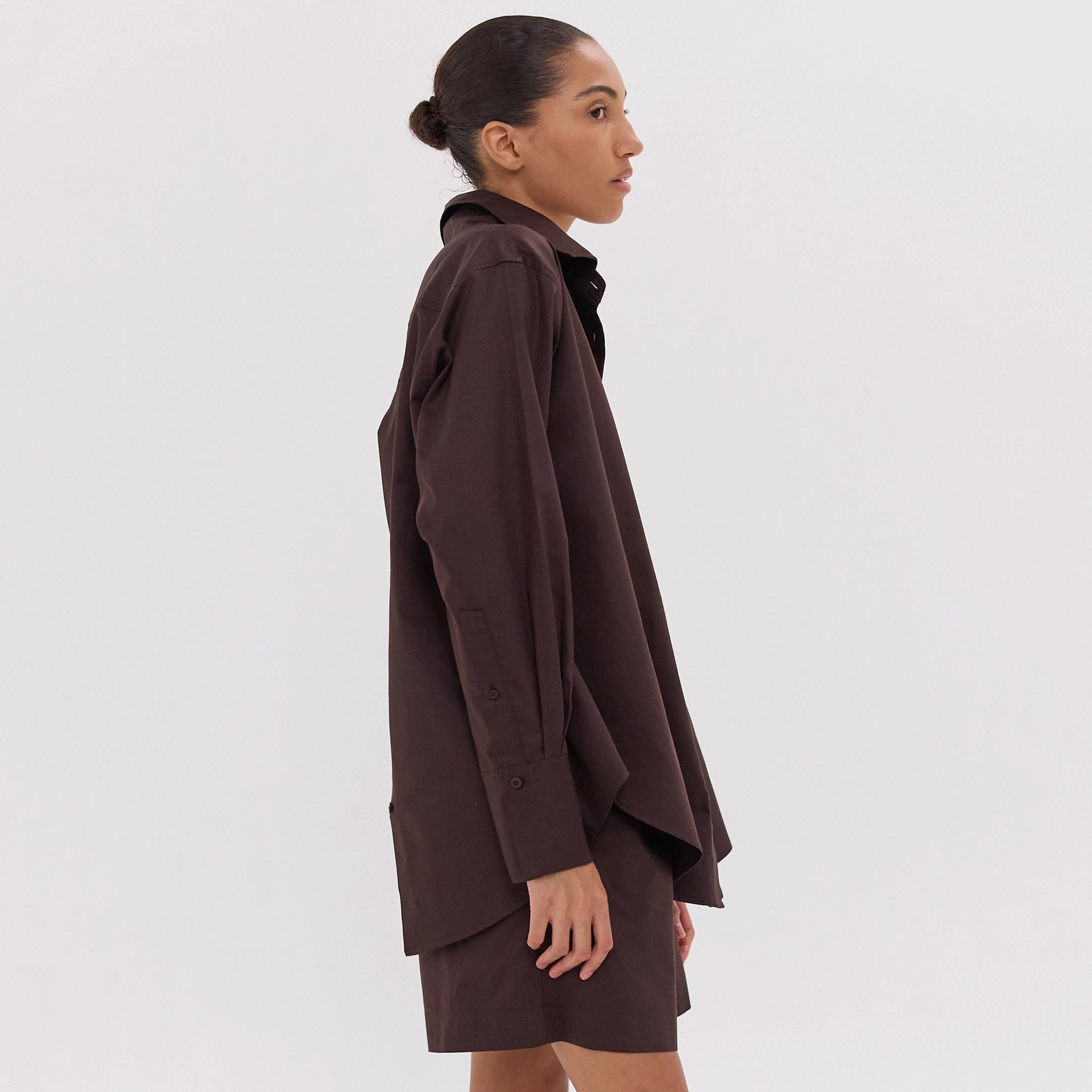Woman wearing a brown coat on a white background
