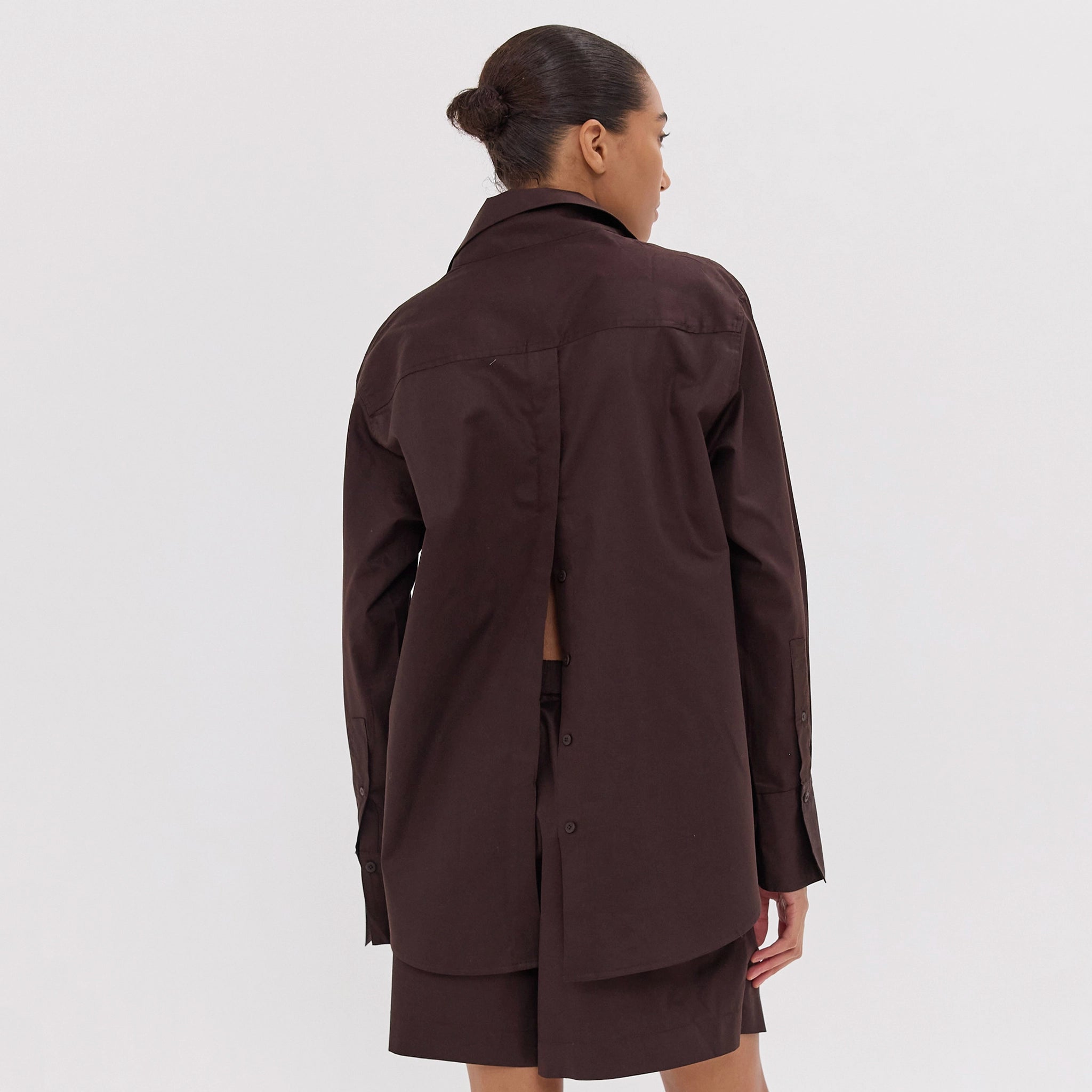 Woman wearing a brown coat on a white background