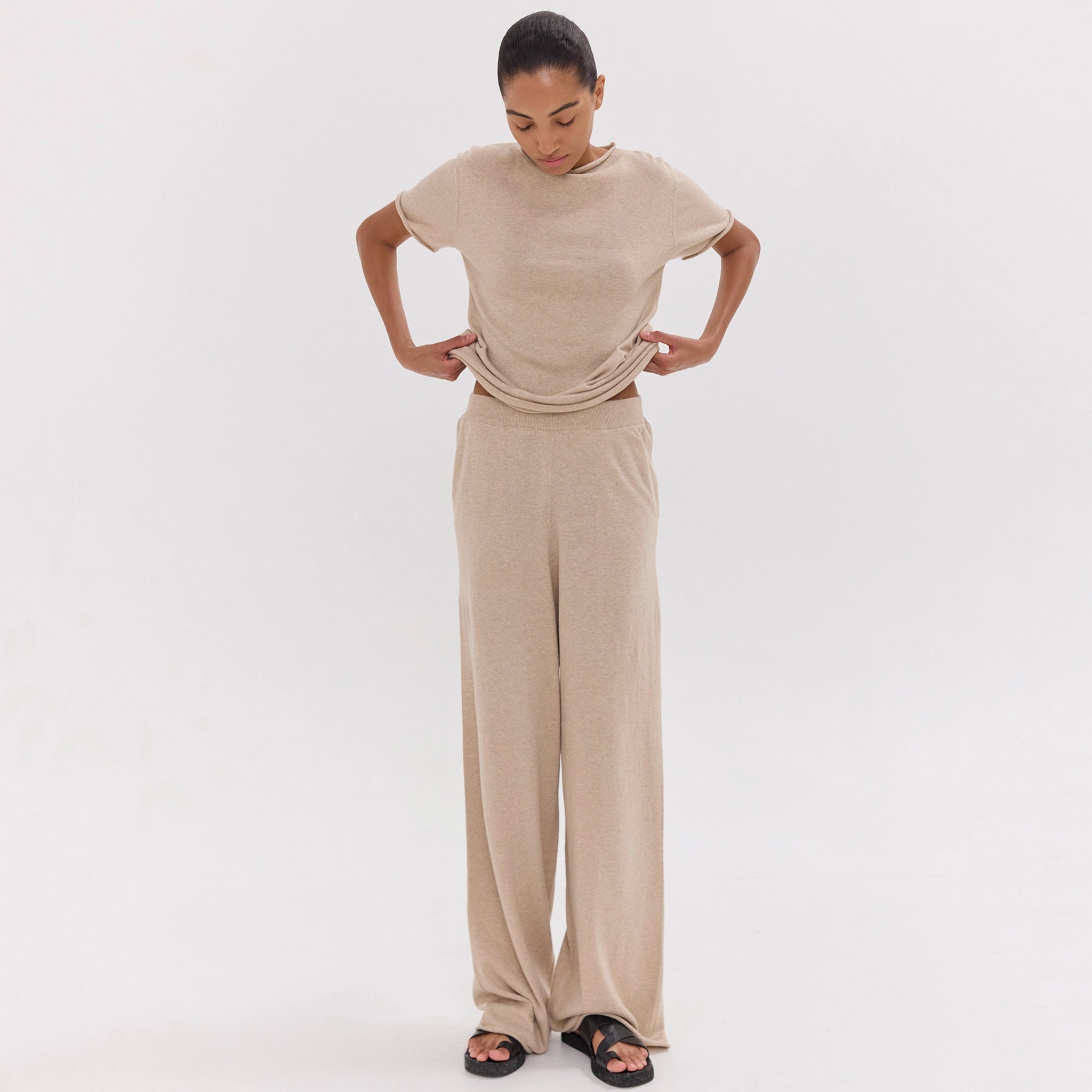 Woman wearing a beige outfit on a white background