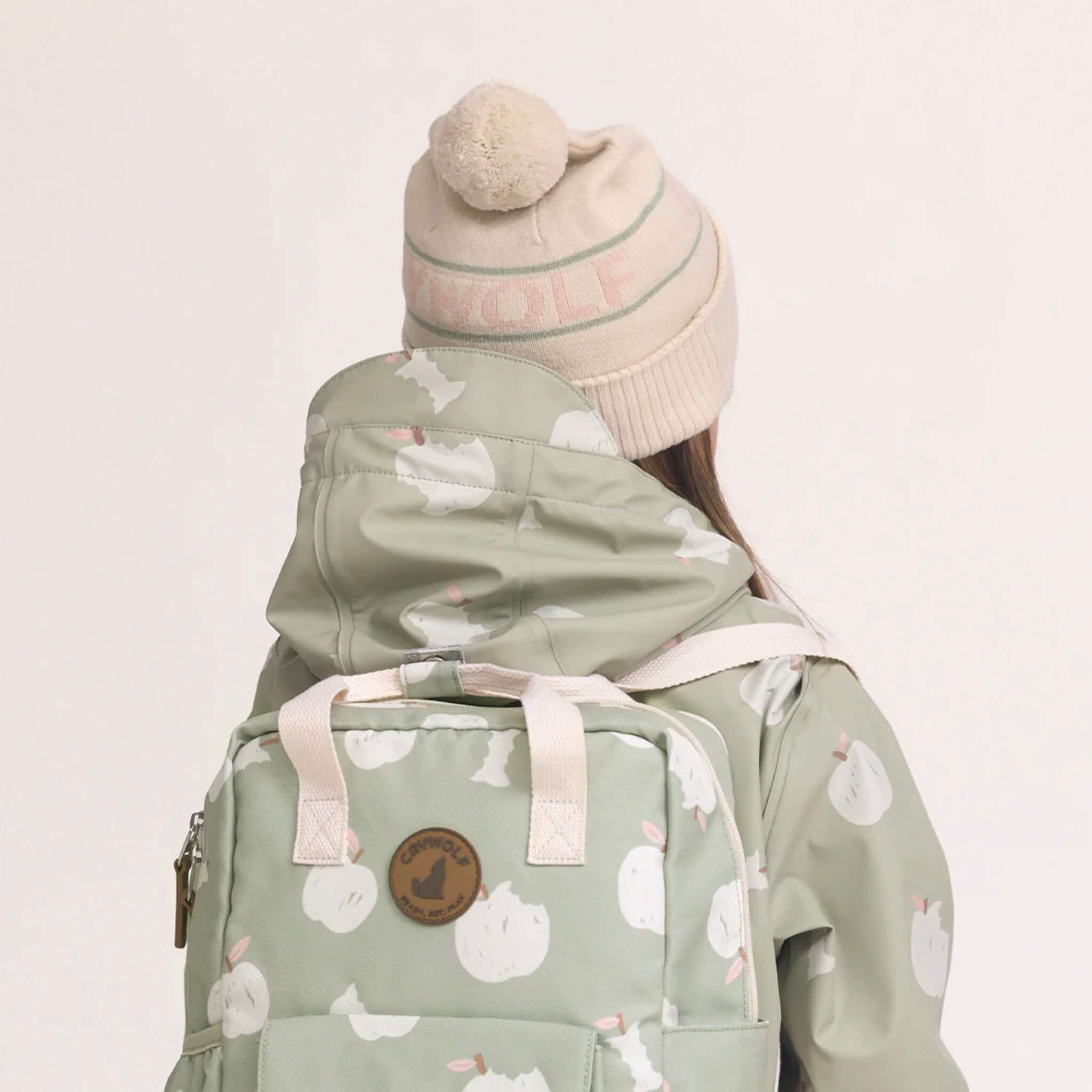 Alt Tag: Crywolf Alpine Beanie - Harvest on child outdoors, retro ski pom pom beanie paired with jacket and backpack