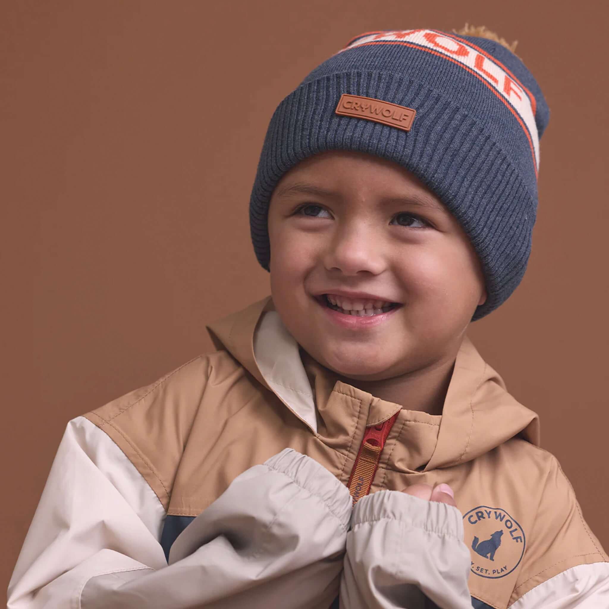 Alt Tag: Crywolf Alpine Beanie -  Indigo on child wearing navy retro ski beanie with pom pom, cosy winter knit hat