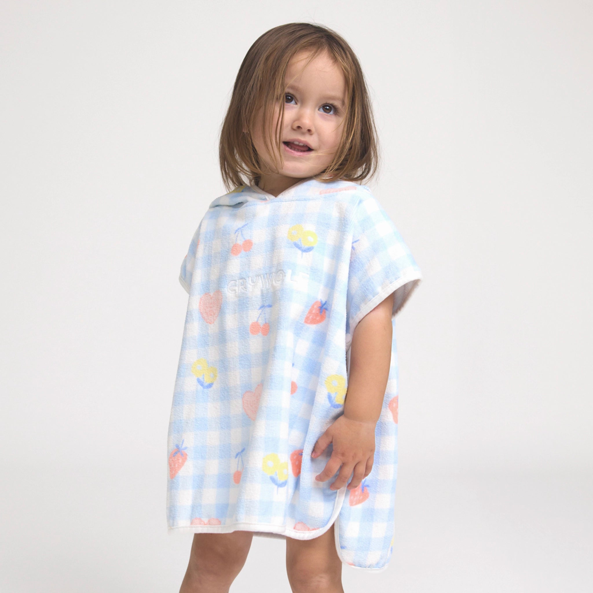 Child wearing a light blue poncho with colorful cloud pattern on a white background