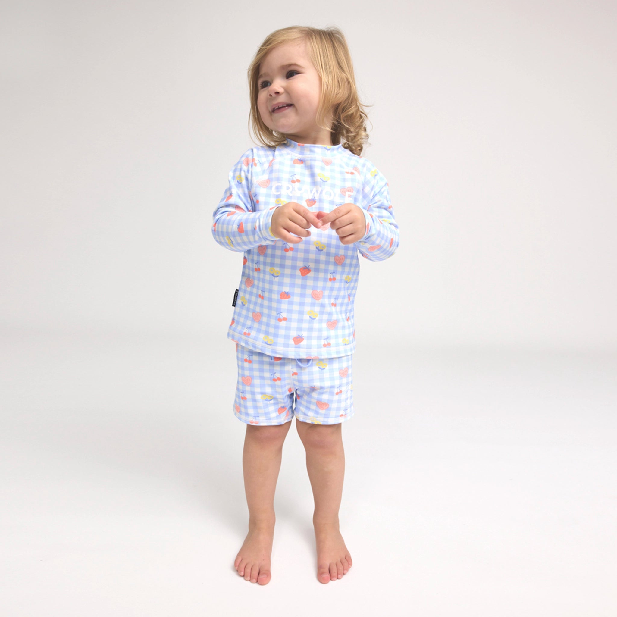 Toddler wearing patterned baby swim shorts on white background
