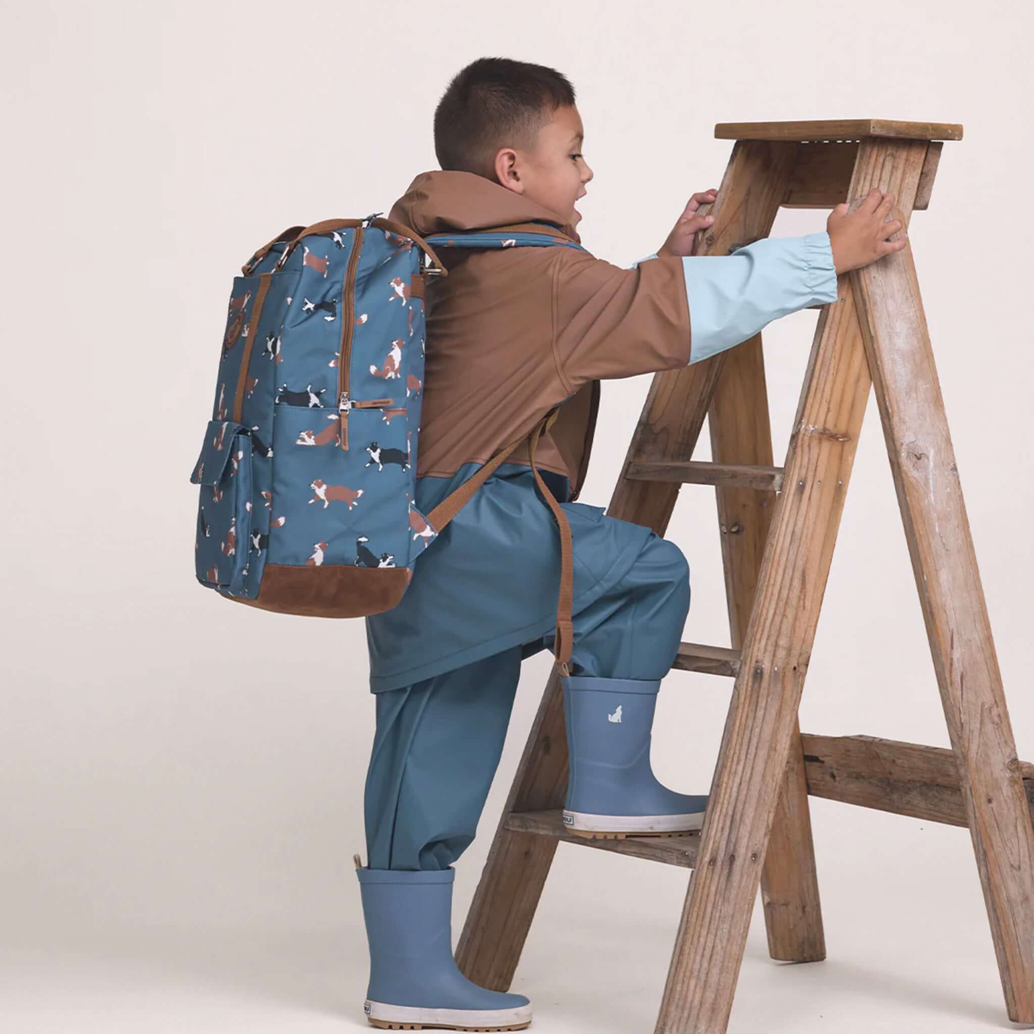 Alt Tag: Crywolf Knapsack - Collies kids waterproof backpack in recycled materials, worn by child climbing ladder for school travel and play