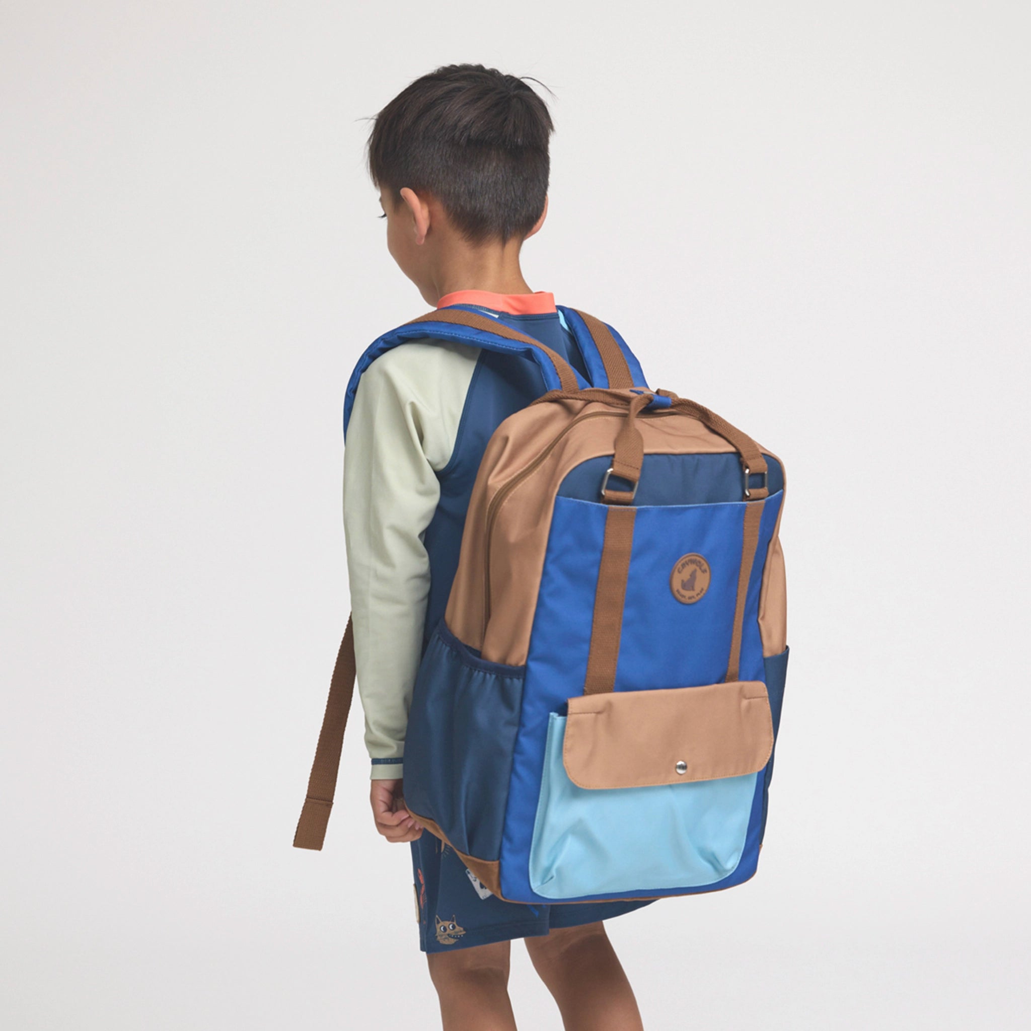 Person wearing a blue and brown backpack on a white background
