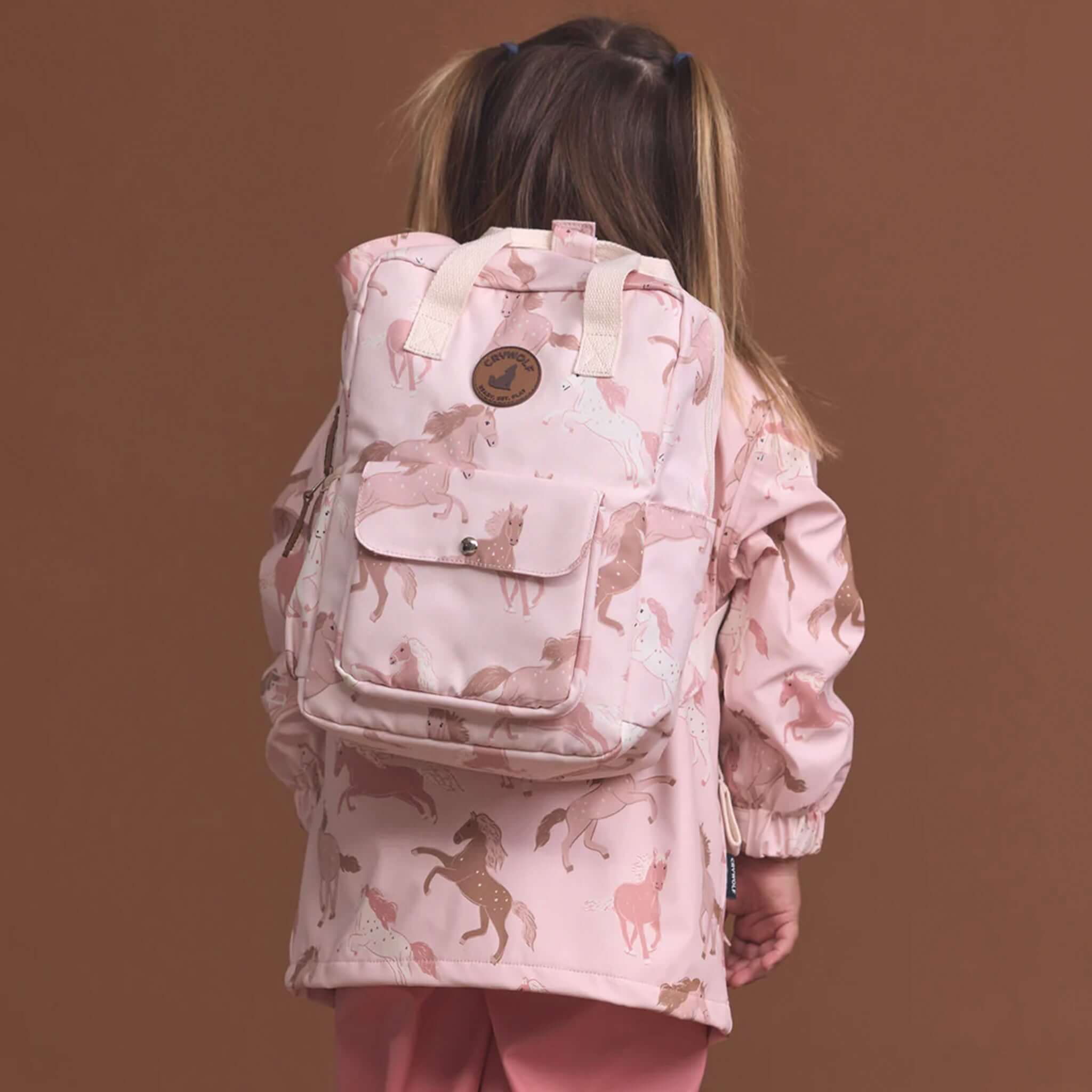 Alt Tag: Crywolf Mini Backpack - Blush Ponies worn by child, blush pink pony print mini backpack for kindy, playdates, everyday adventures
