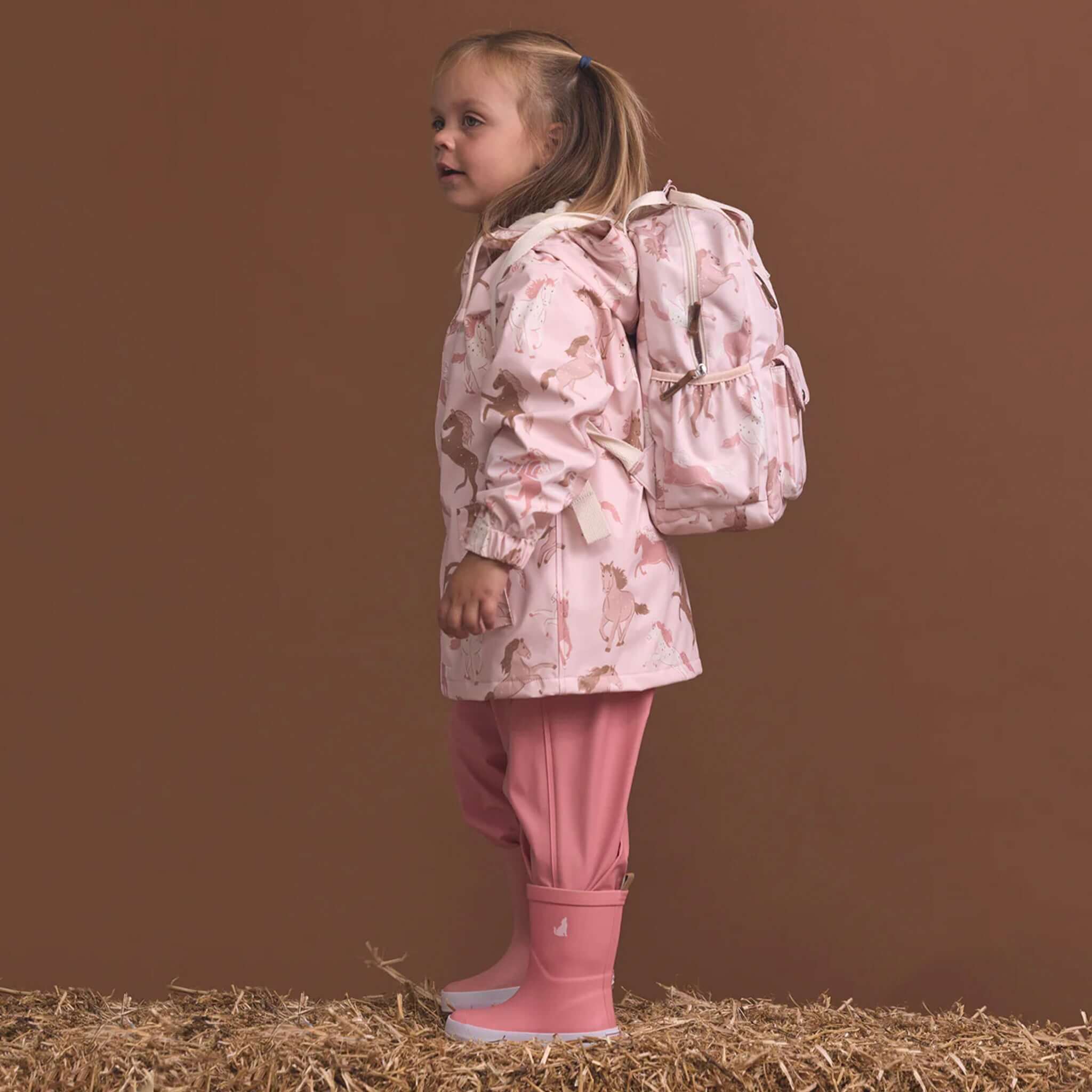 Alt Tag: Crywolf Mini Backpack - Blush Ponies worn by little girl, lightweight recycled 9L kids backpack with water-resistant finish for kindy days