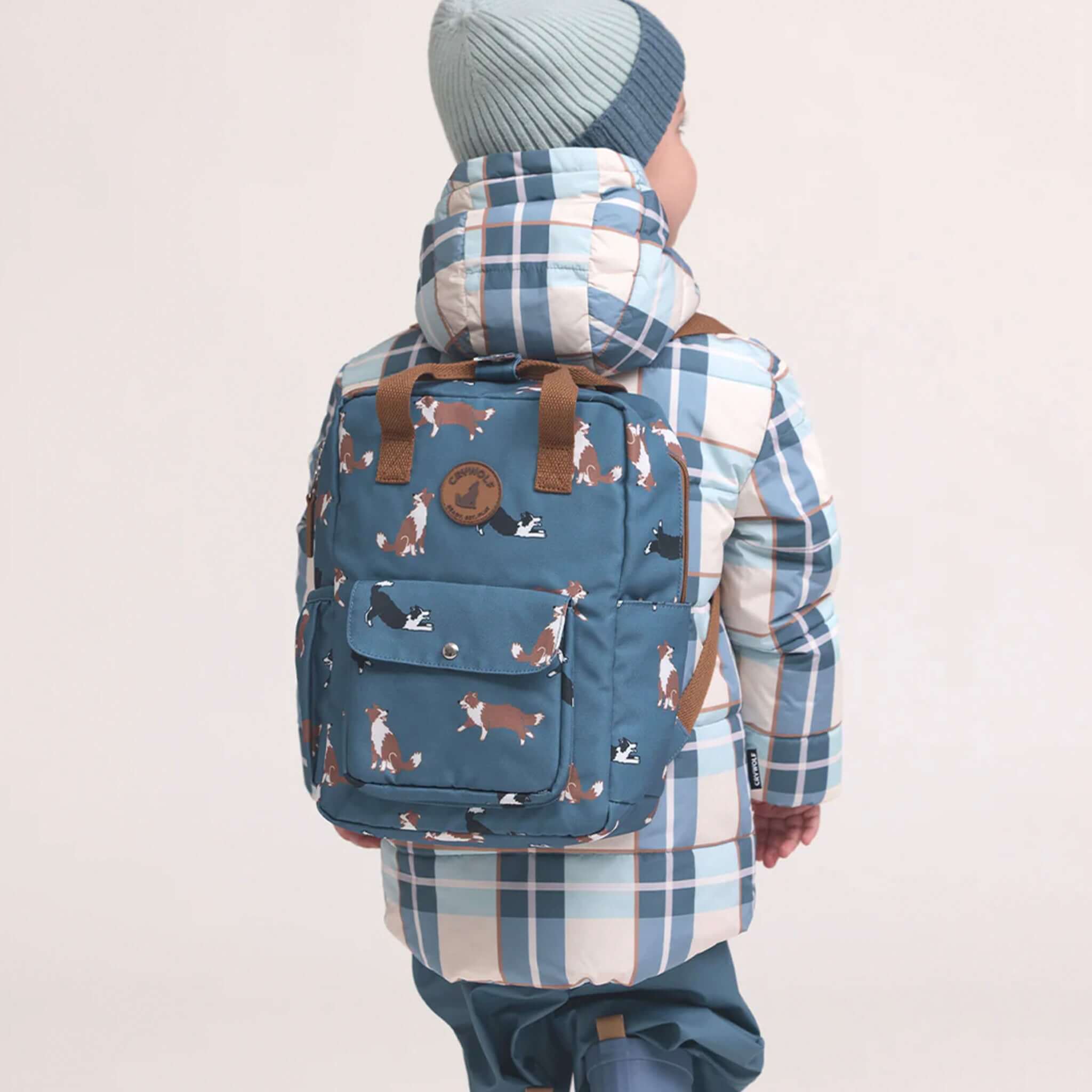 Crywolf Mini Backpack - Collies on child model, blue dog-print 9L kids backpack with front pocket, water-resistant recycled fabric