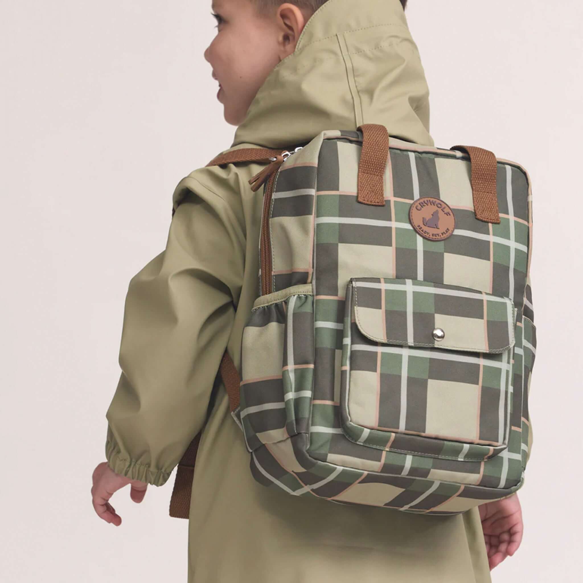 Alt Tag: Crywolf Mini Backpack - Field Plaid kids 9L mini backpack in green plaid, worn by child, lightweight recycled water-resistant daypack