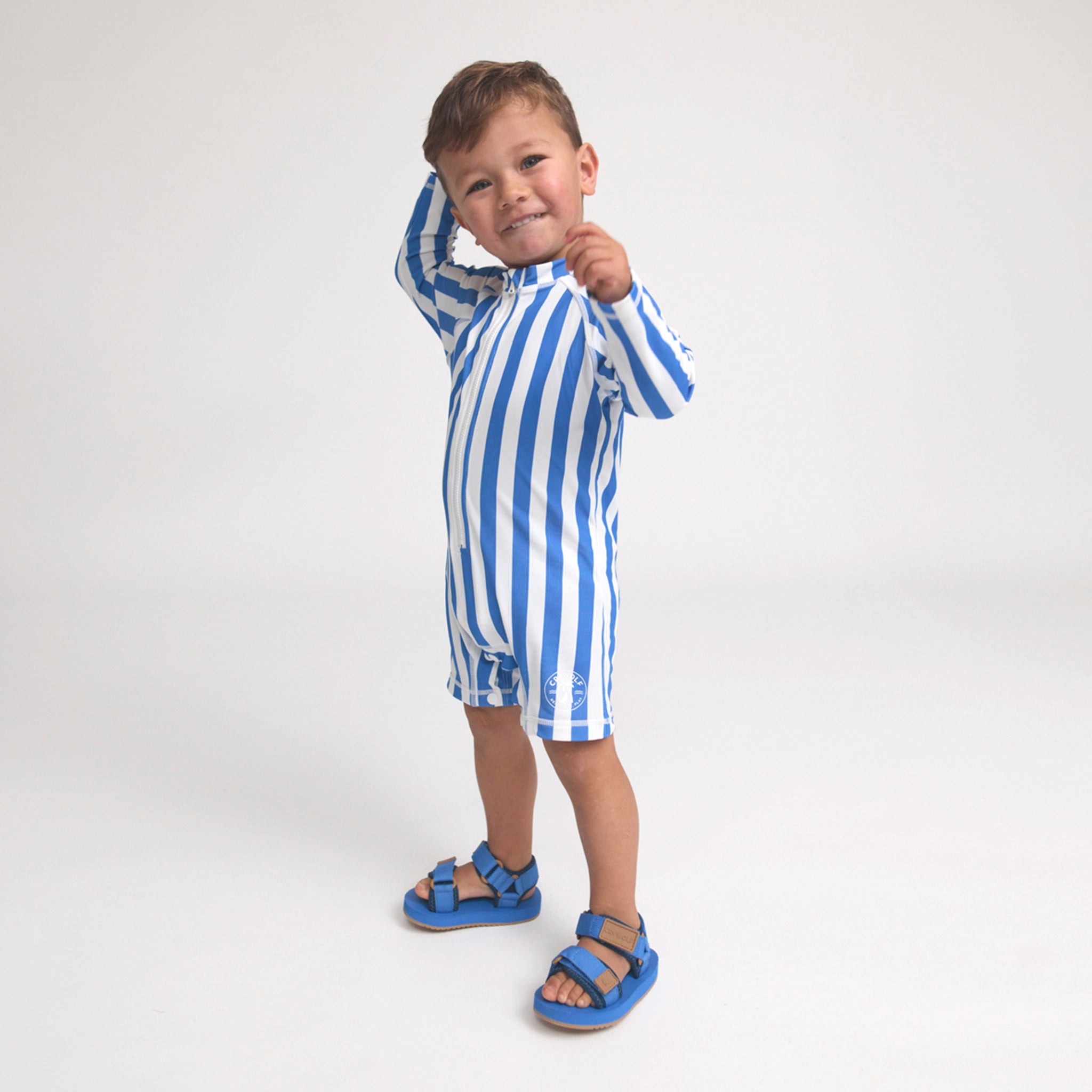 Child wearing a blue and white striped swimsuit on a white background