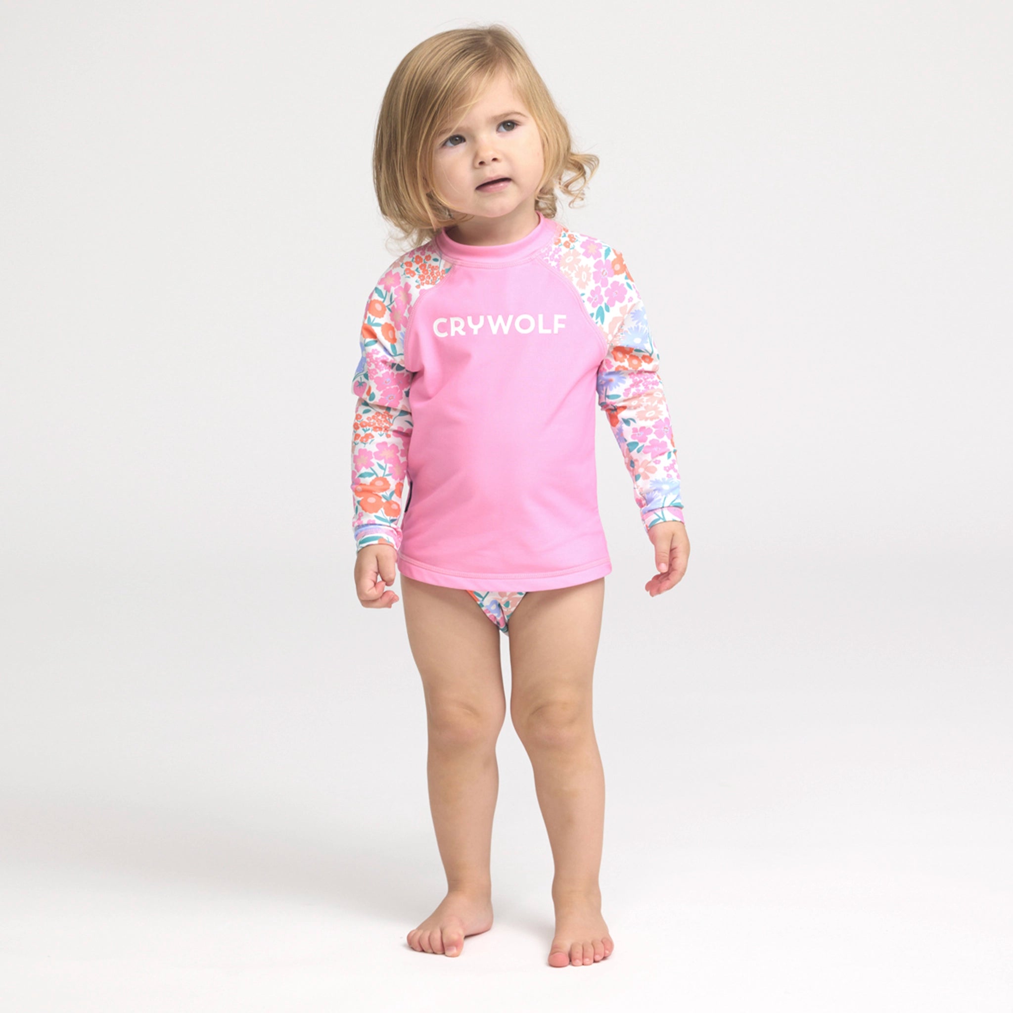 Toddler wearing a floral swim nappy on a white background