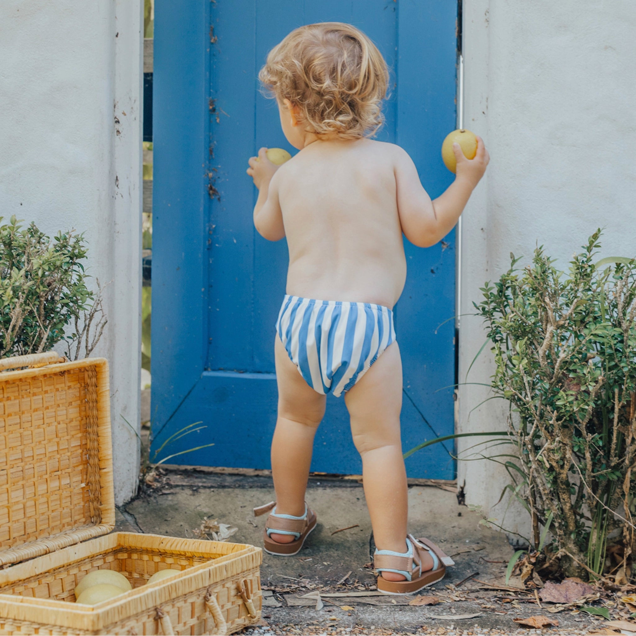 Toddler wearing a blue and white striped swim nappy