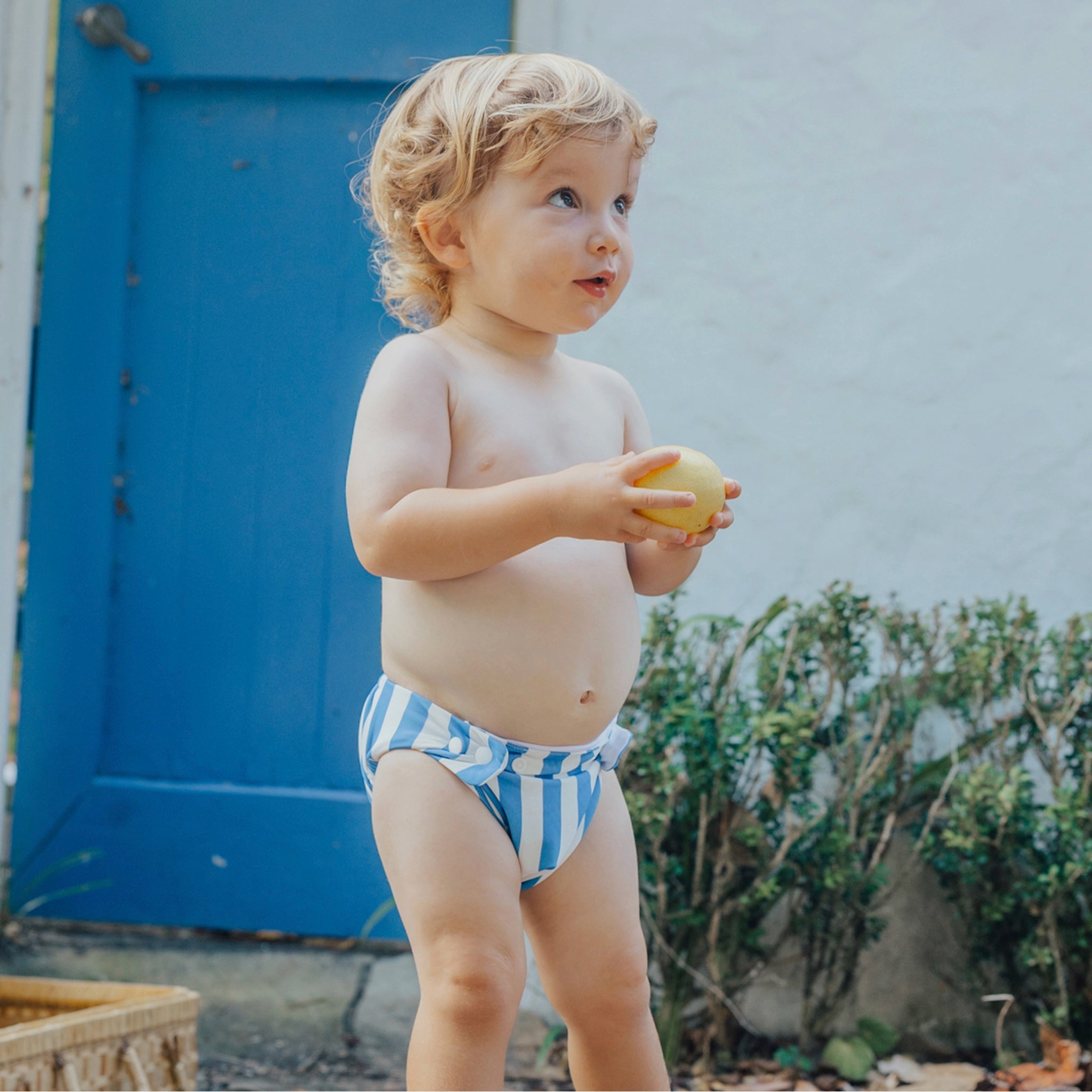 Toddler wearing a blue and white striped swim nappy