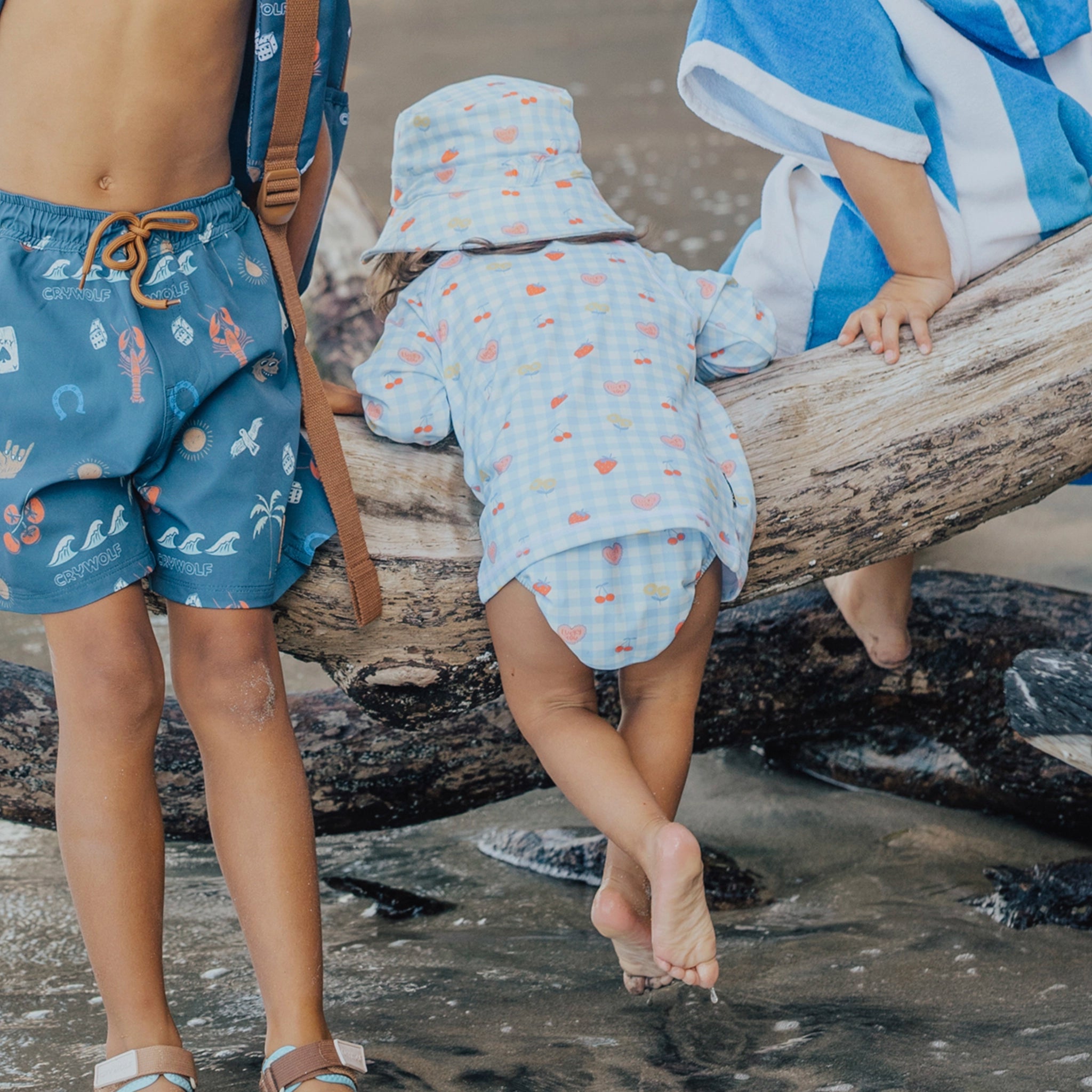 Toddler wearing a  blue and pink checkered swim nappy at the beach