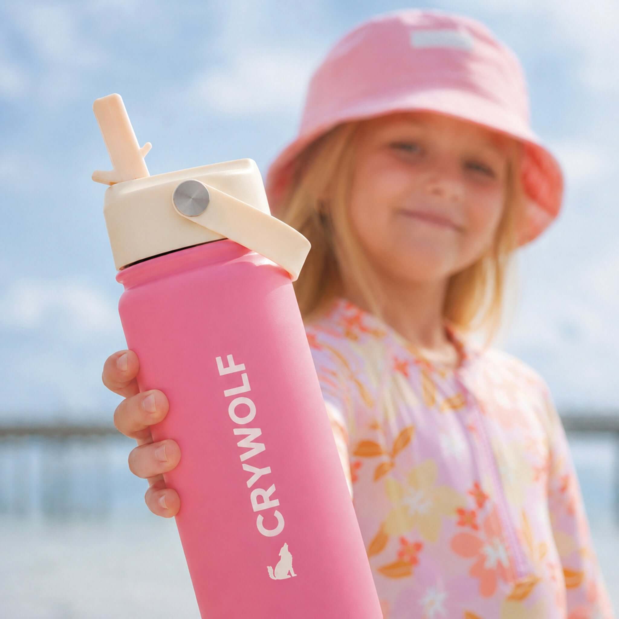 Crywolf Stainless Steel Drink Bottle 545ml - Hibiscus held by a smiling child outdoors.