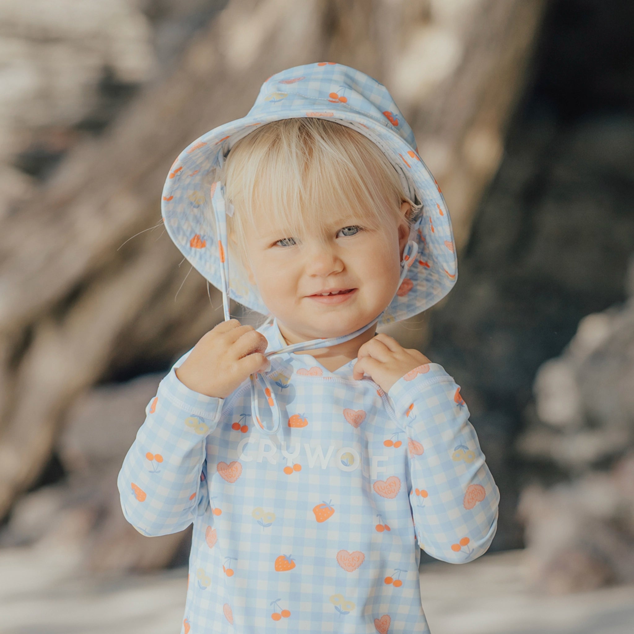 Child wearing a patterned sun hat and outfit outdoors