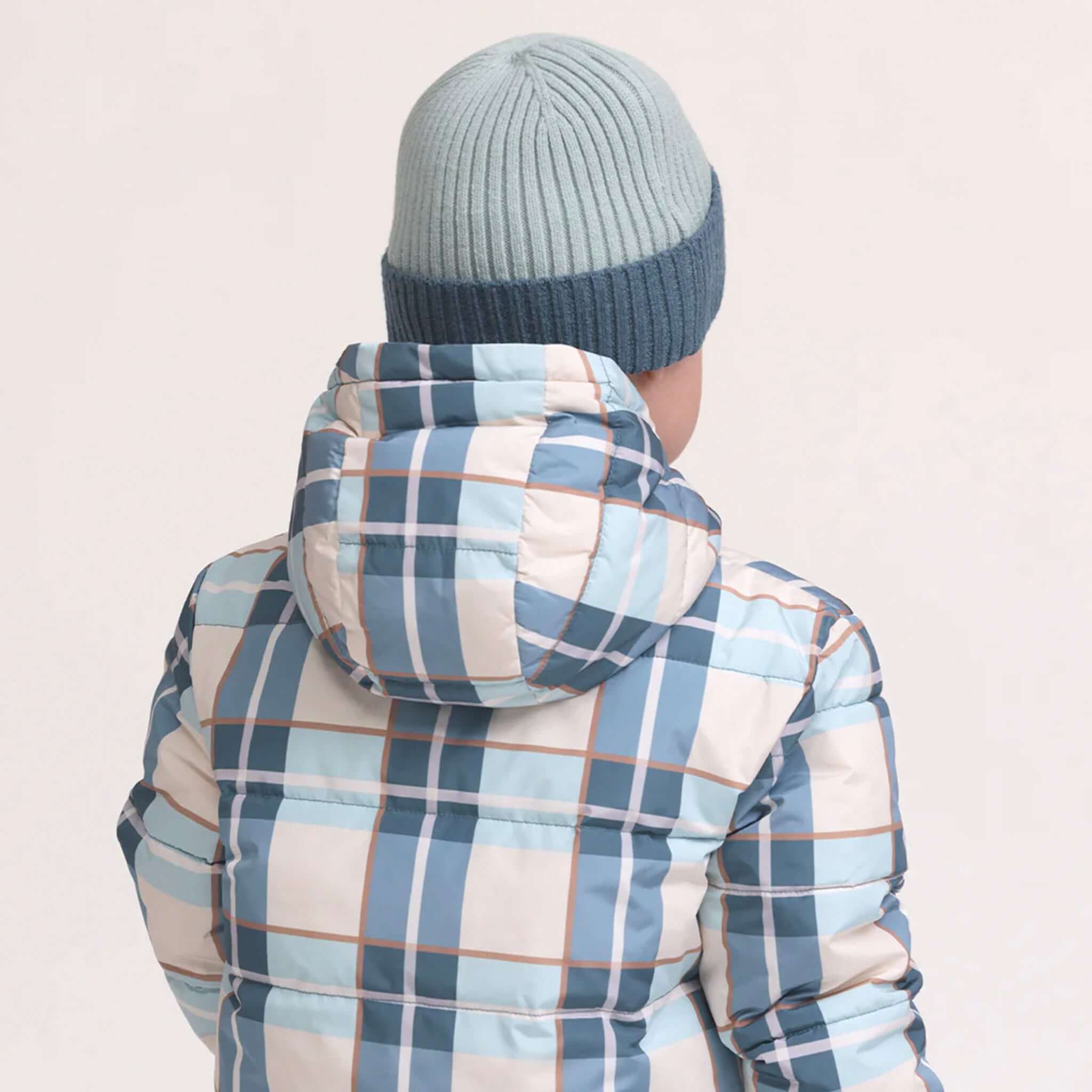 Alt Tag: Crywolf Tasman Beanie - Blue on child model, slimline ribbed knit beanie layered under hood for winter adventures
