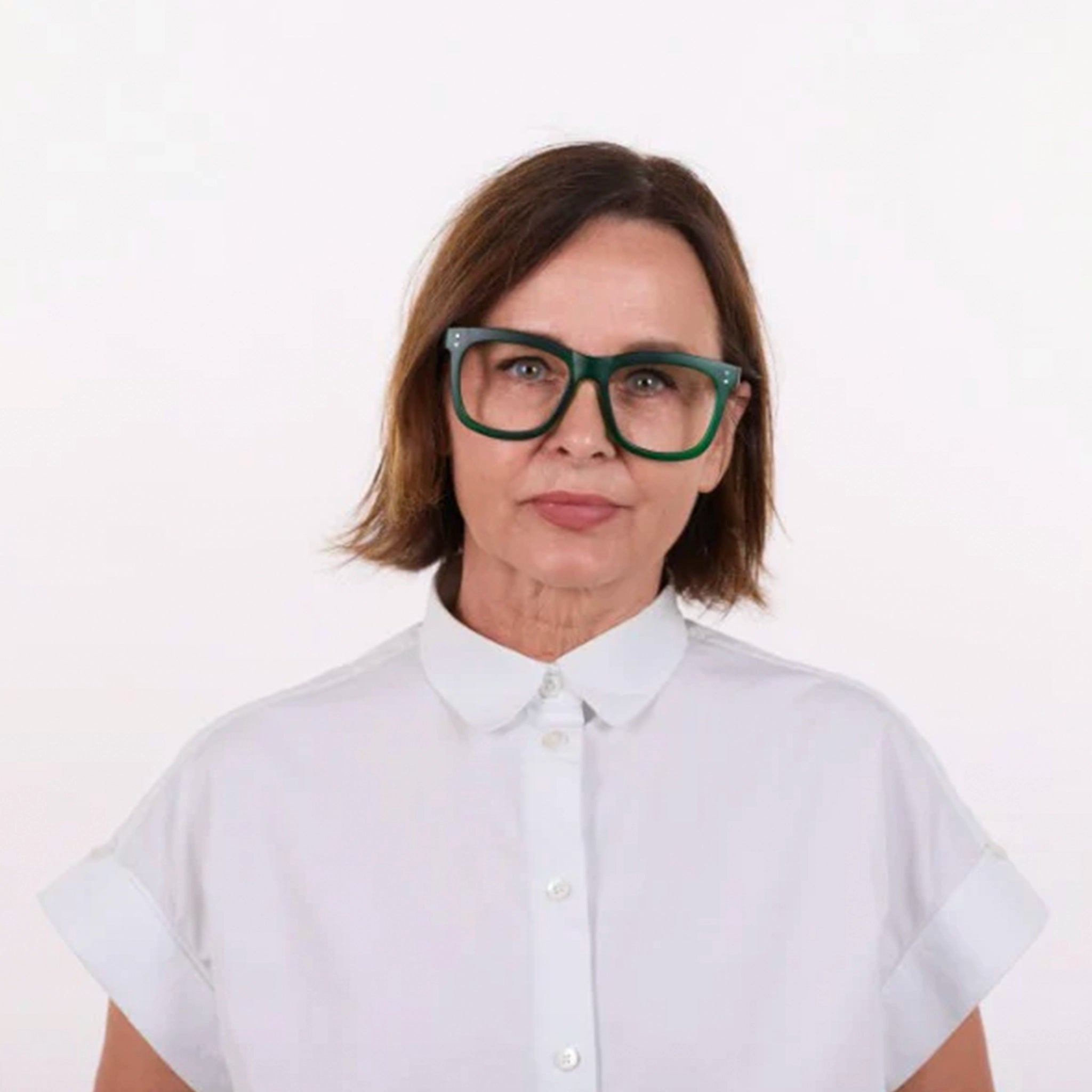 Woman wearing a white shirt and green glasses on a white background