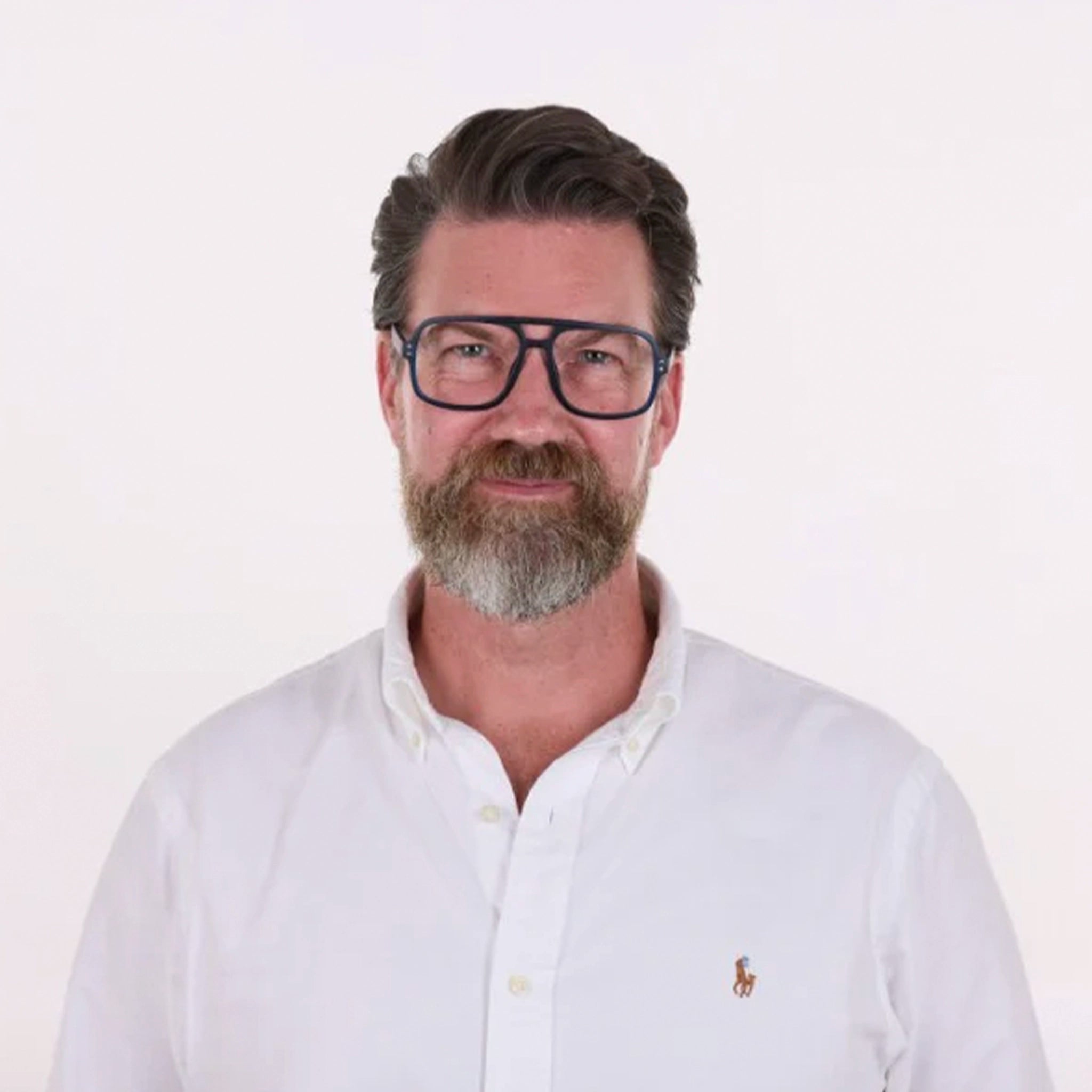 Man wearing glasses and a white shirt with a logo on a white background