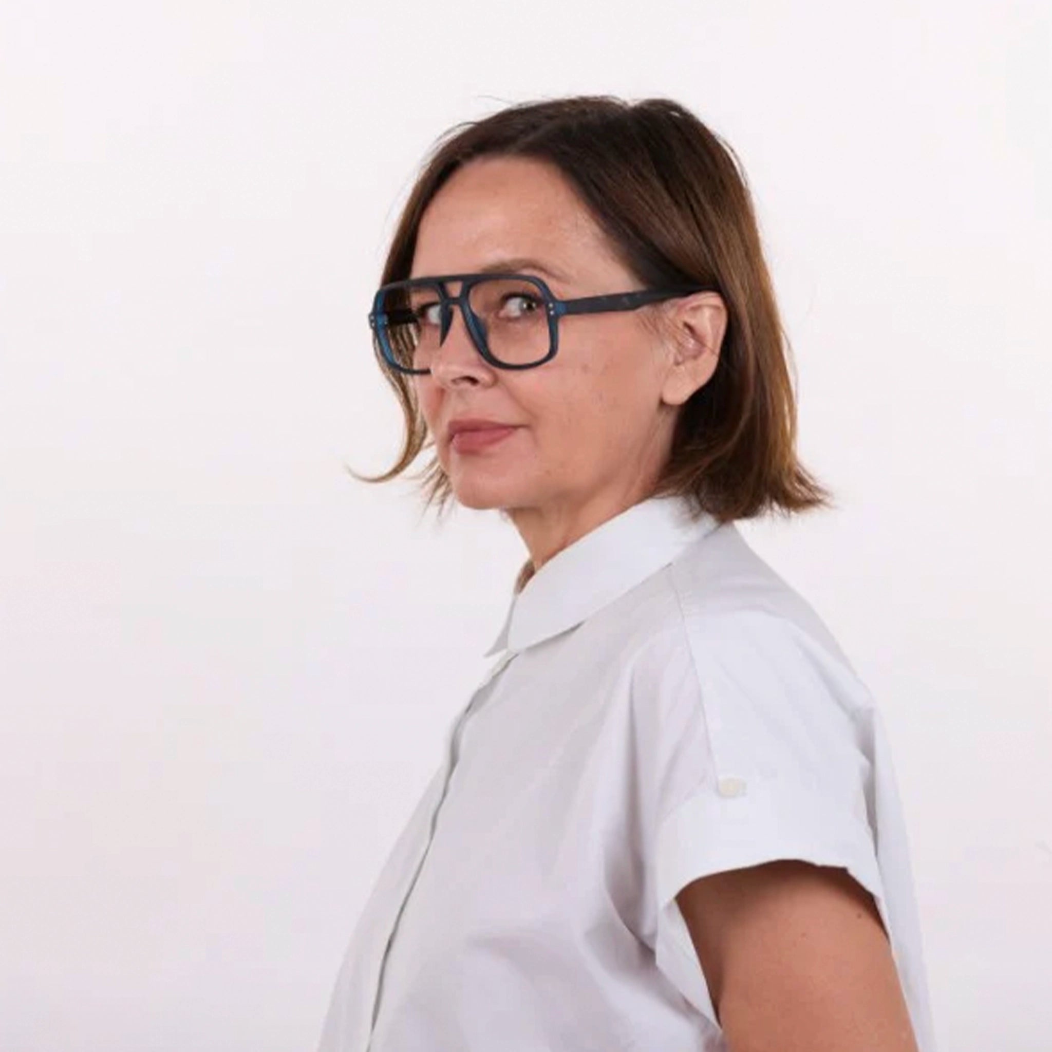 Woman wearing a white shirt and blue glasses on a white background