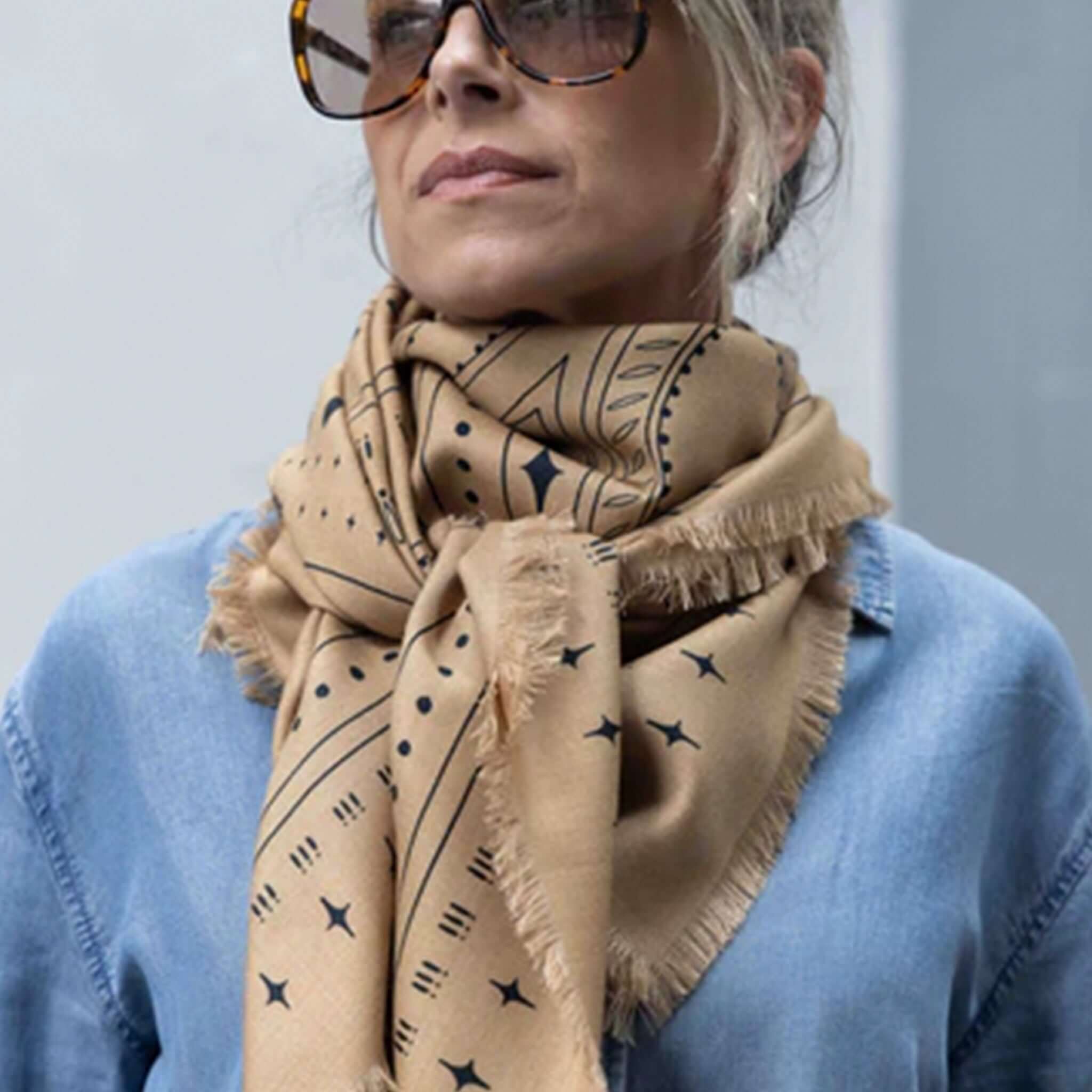 Dark Hampton x Ellie Compton The Holden Wool Silk Scarf styled elegantly in a tan and navy design, worn with a casual denim shirt.