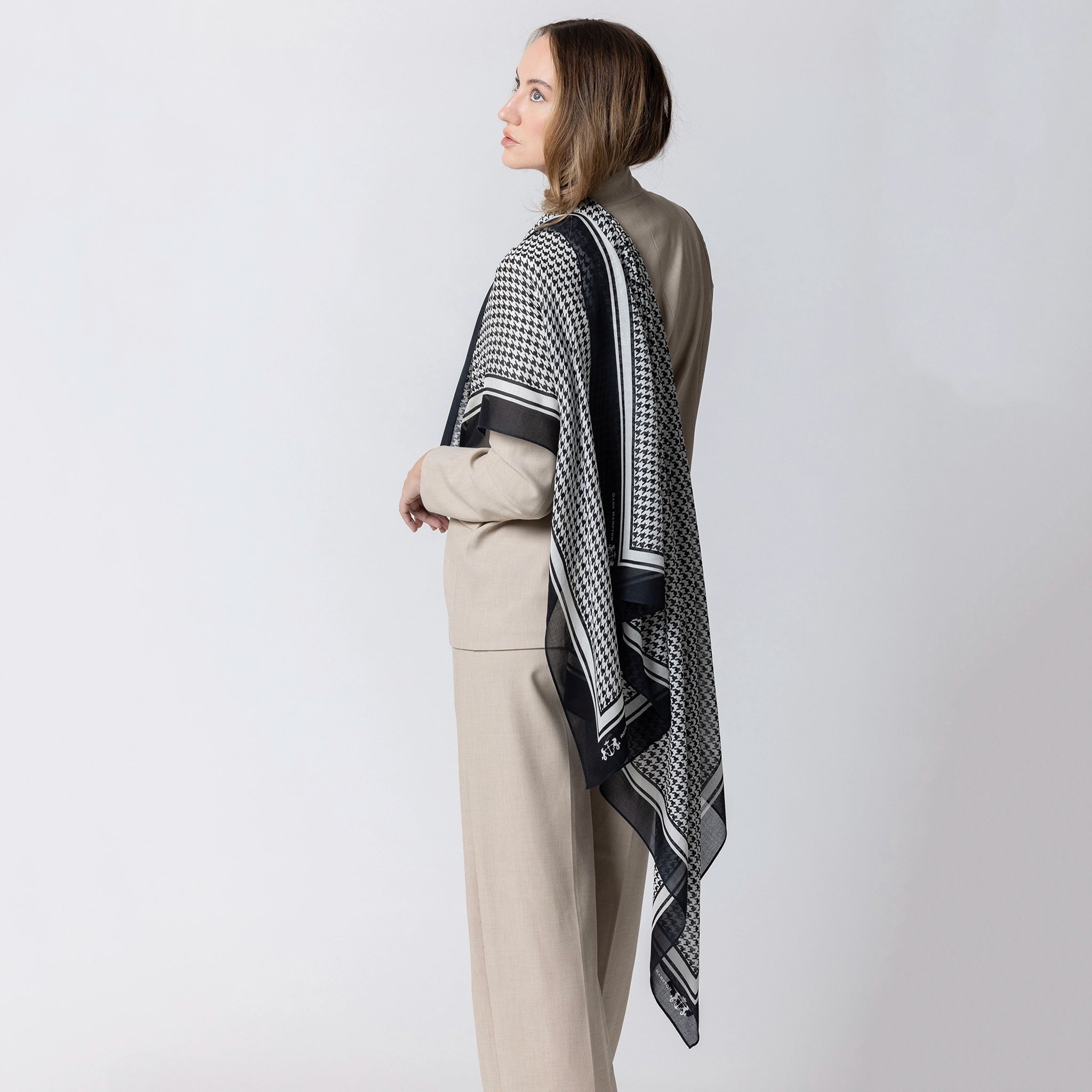 Woman wearing a patterned scarf on a plain background