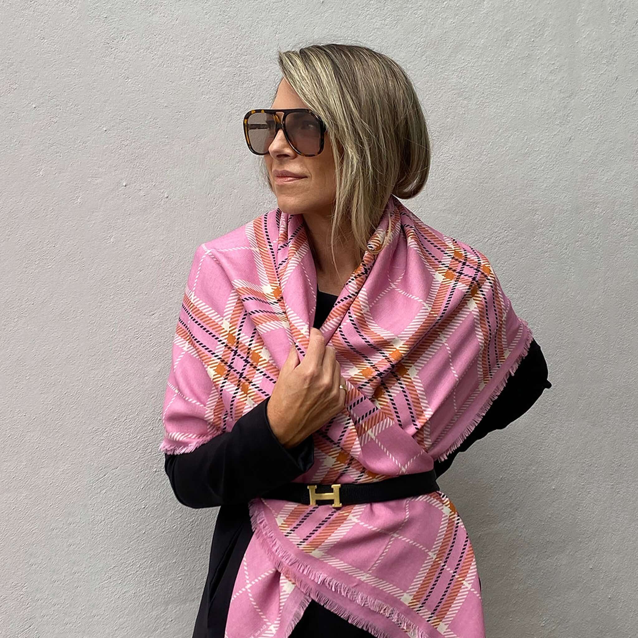 Model showcasing the Dark Hampton the McRae Wool Silk Scarf in pink, styled with modern accessories.