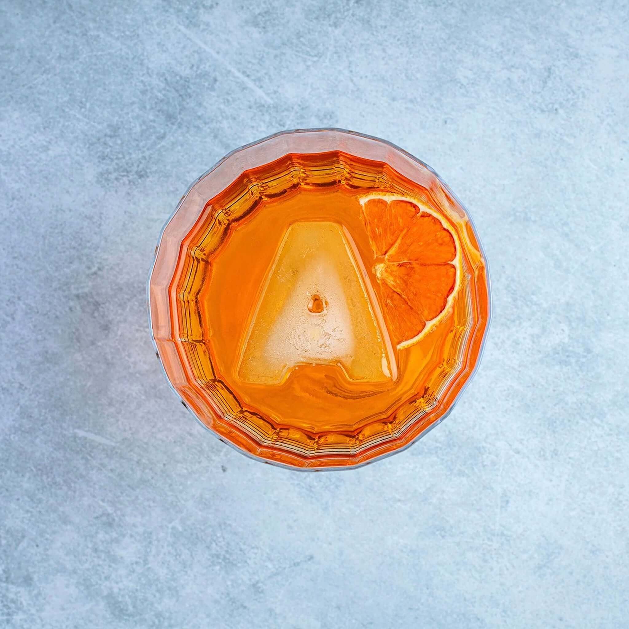 Alt Tag: Drinks Plinks Silicone Ice / Baking Tray - A for Aperol Lovers letter A ice cube in Aperol spritz cocktail with orange slice