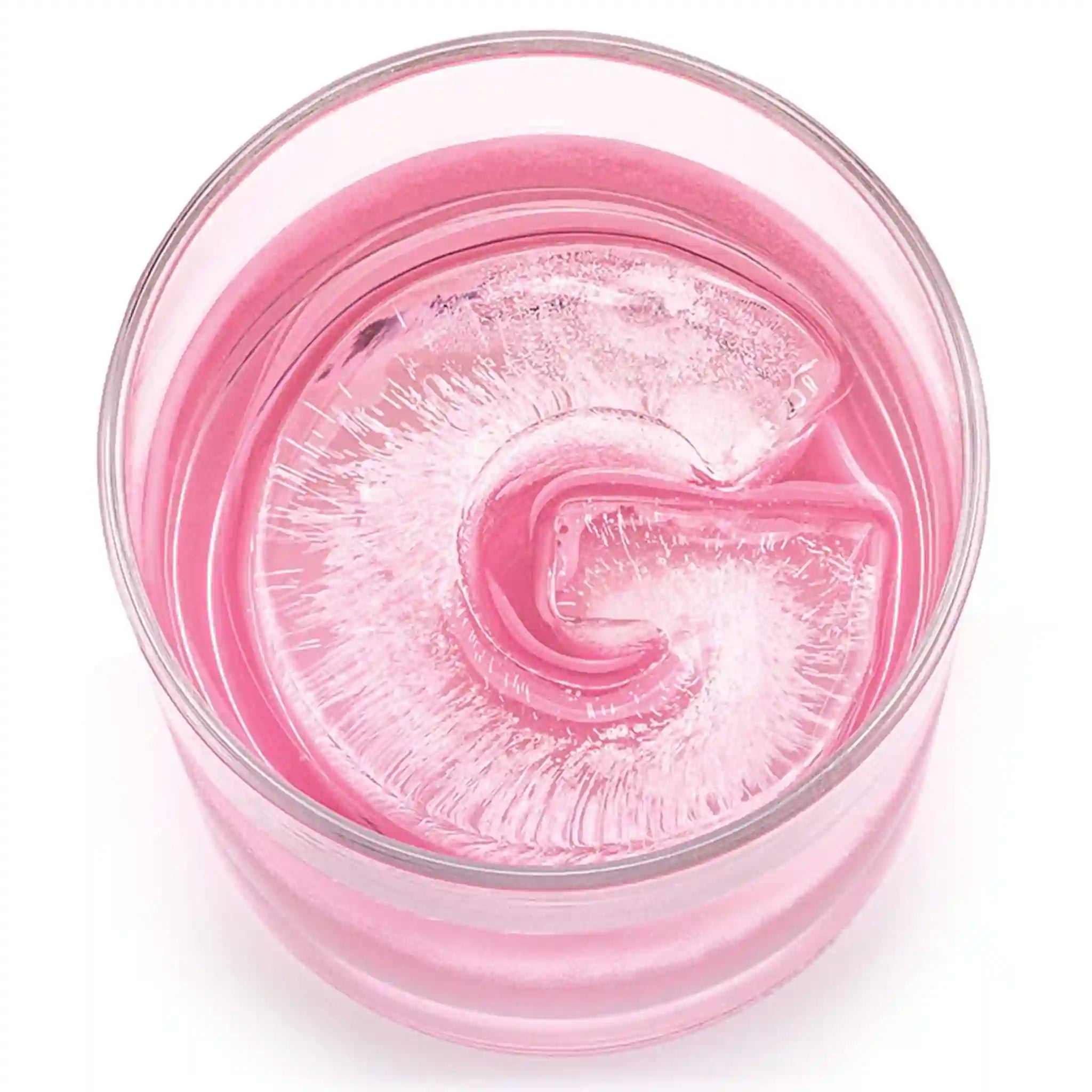Drinks Plinks G ice cube tray with pink drink in a glass.