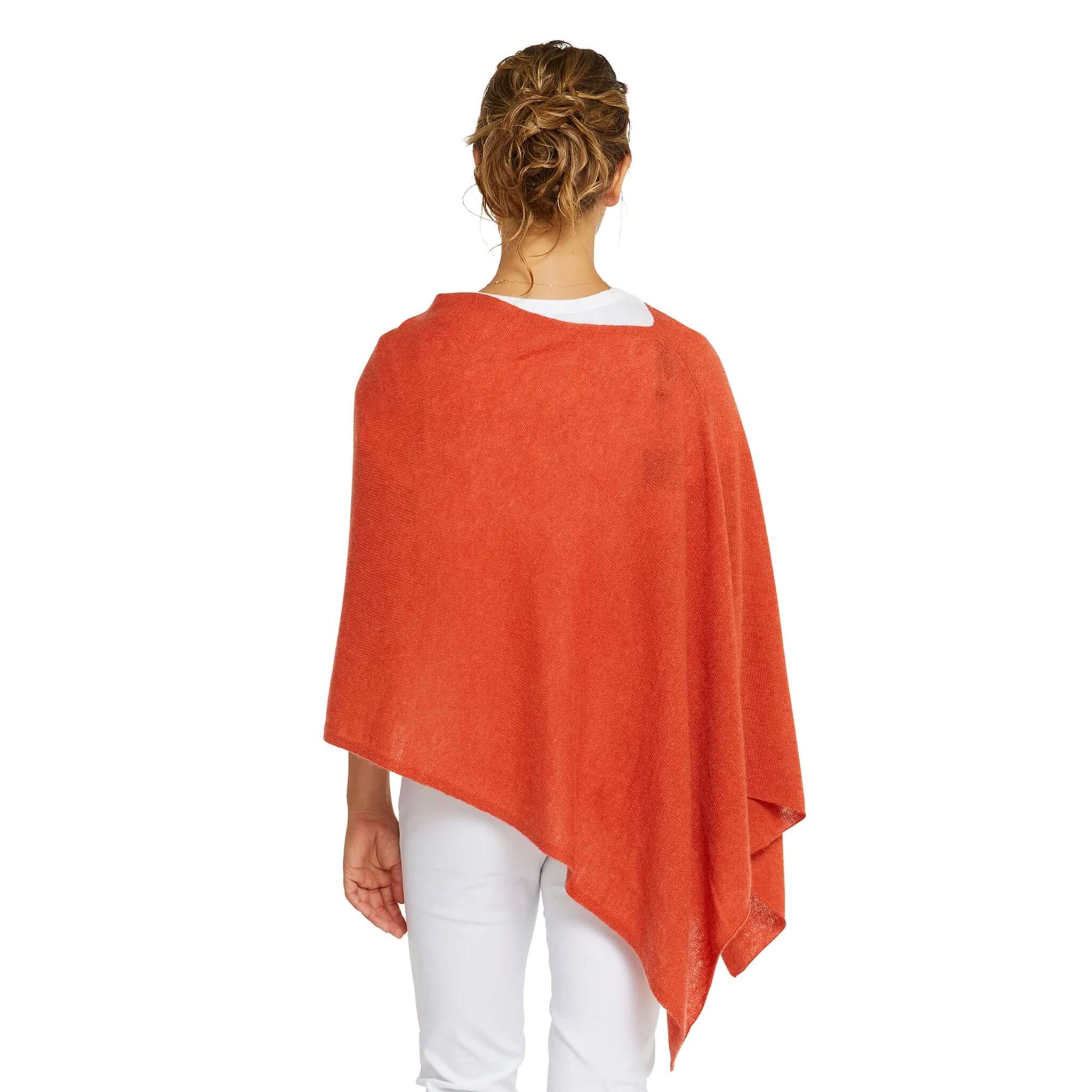 Woman wearing the Esperance & Co Classic Cashmere Topper - Autumn from the back in a vibrant orange color.