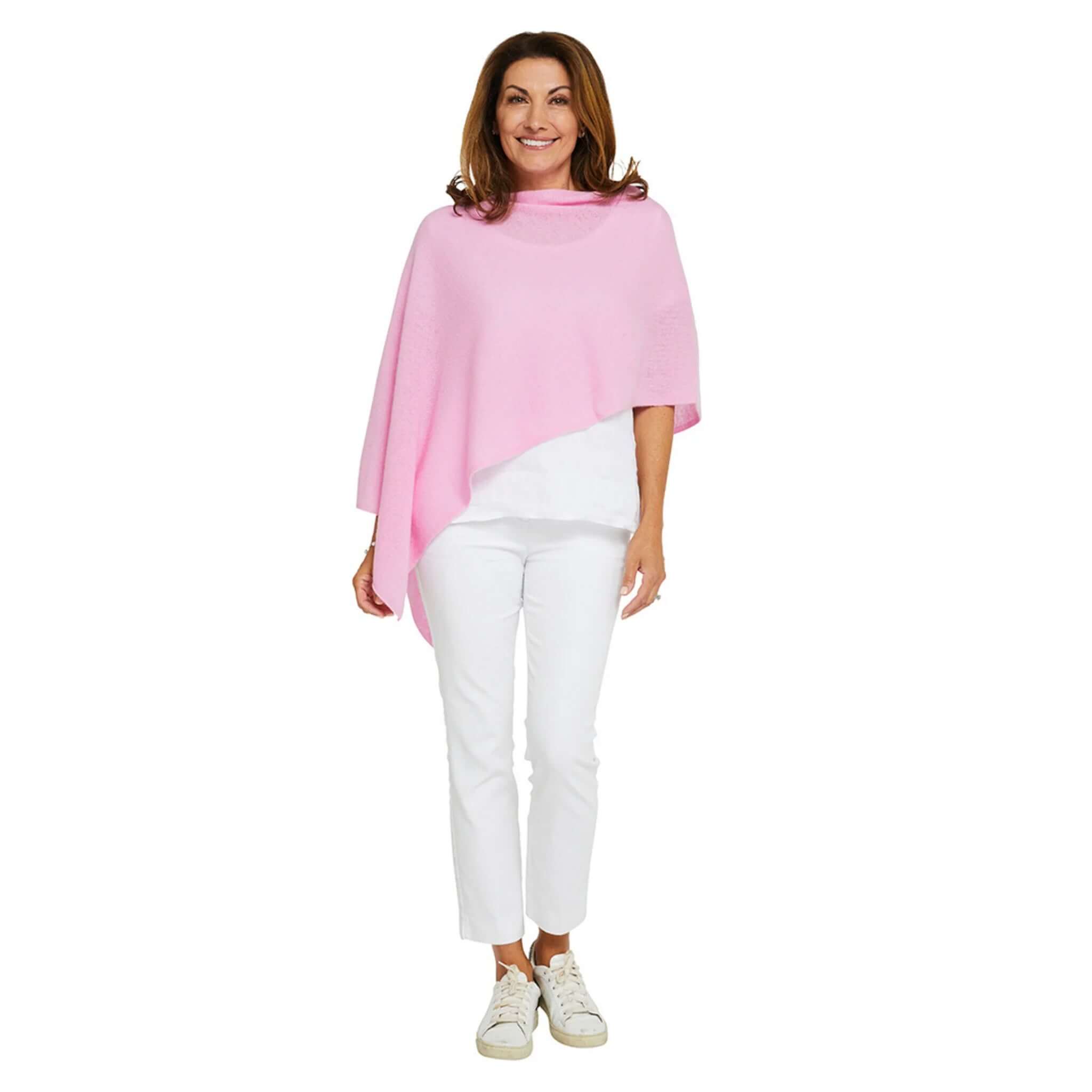 Woman wearing Esperance & Co Classic Cashmere Topper - Glam Pink with white outfit, showcasing versatility and style.