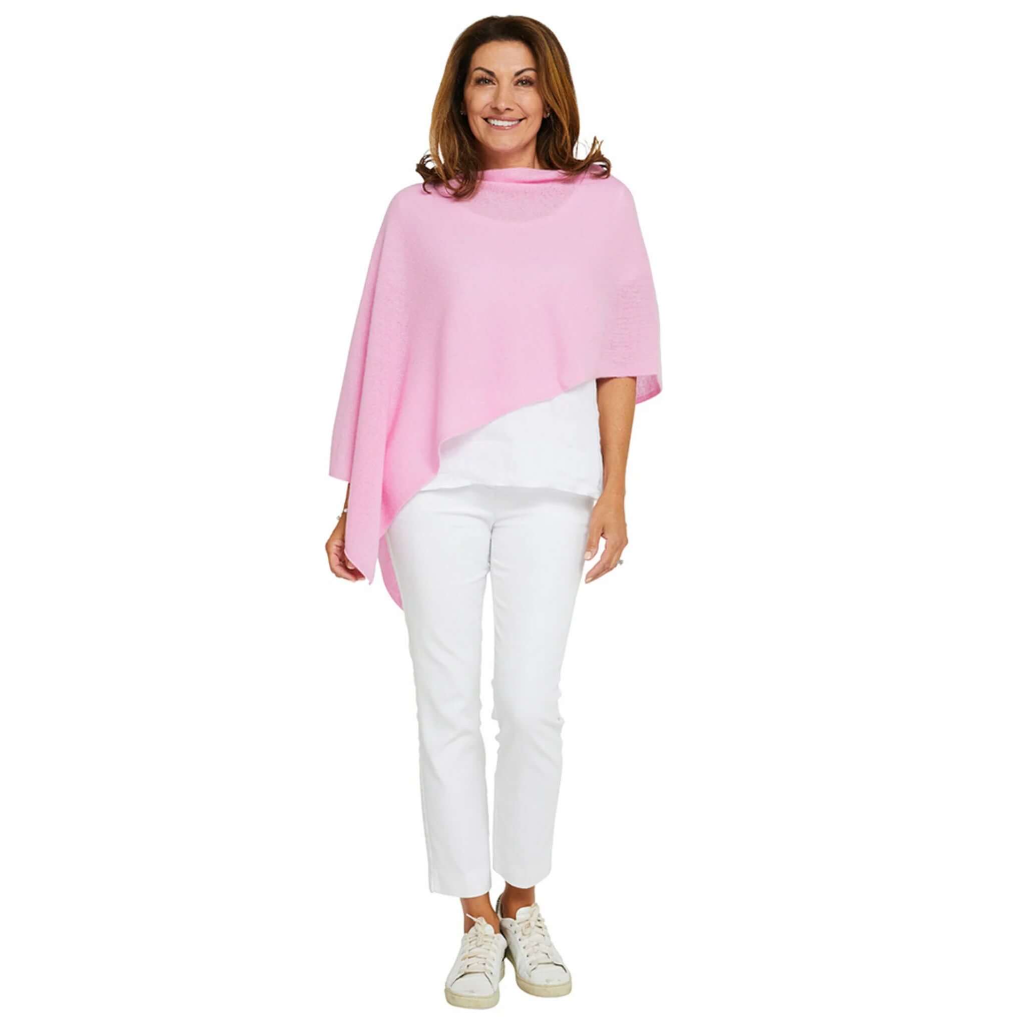Woman wearing Esperance & Co Classic Cashmere Topper - Glam Pink over a white outfit, showcasing its versatility.