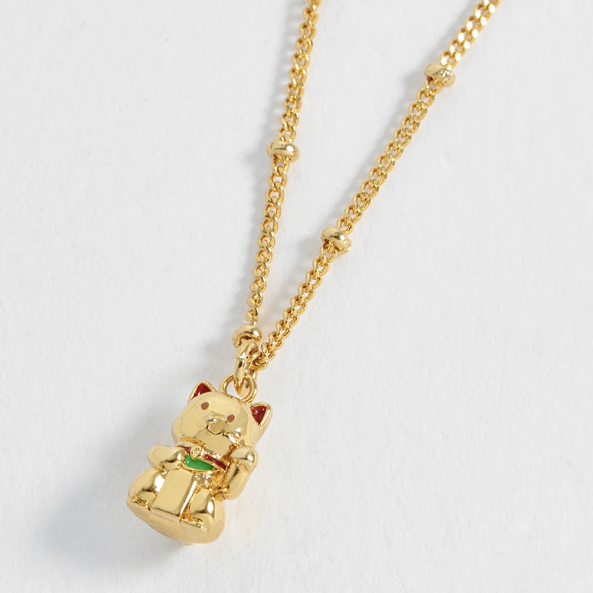 Gold cat pendant necklace on a white background