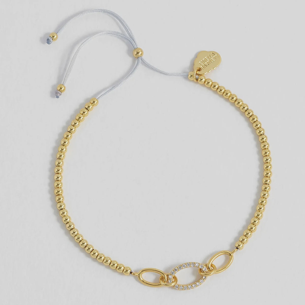 Estella Bartlett Oval Link CZ Louise Bracelet, gold beads and three oval links on an adjustable grey cord