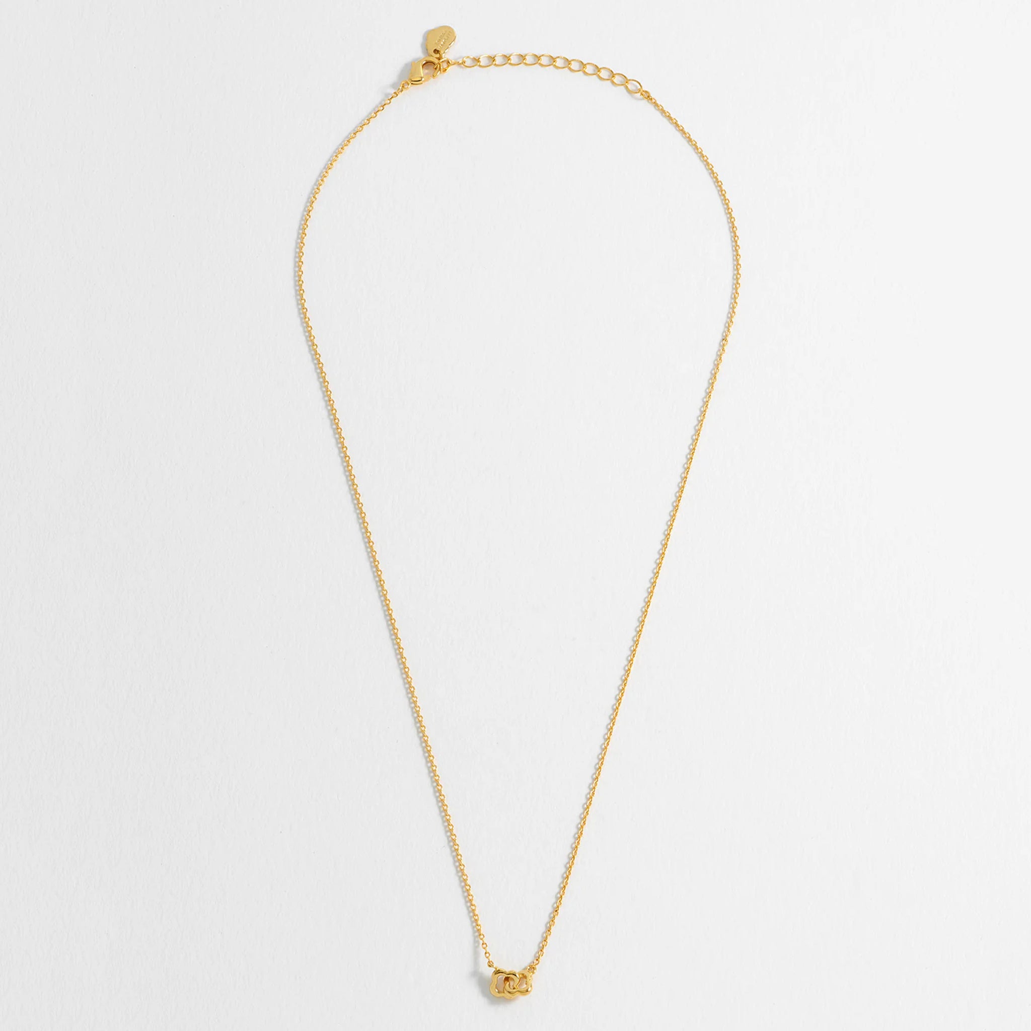 Gold necklace on a light gray background