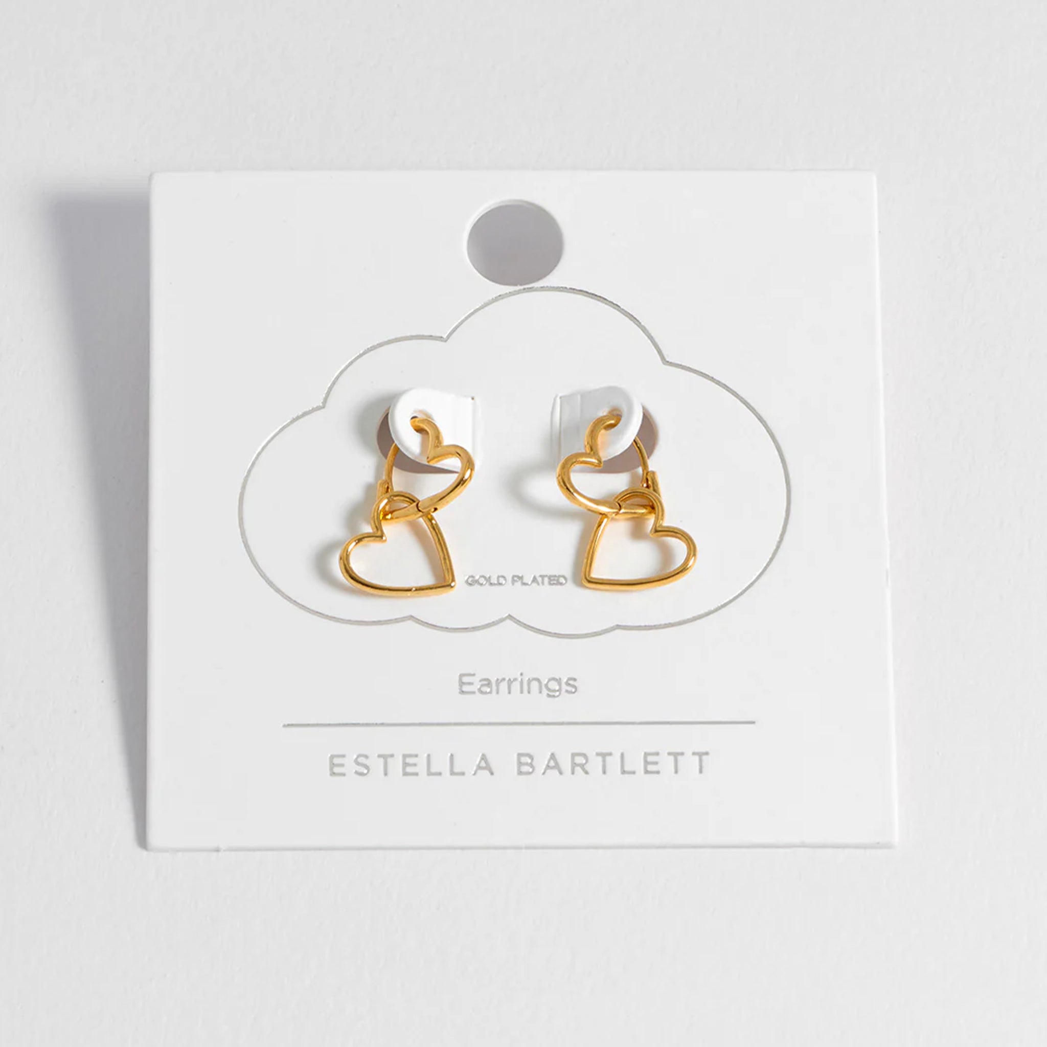 Gold earrings on a white card with 'Estella Bartlett' branding