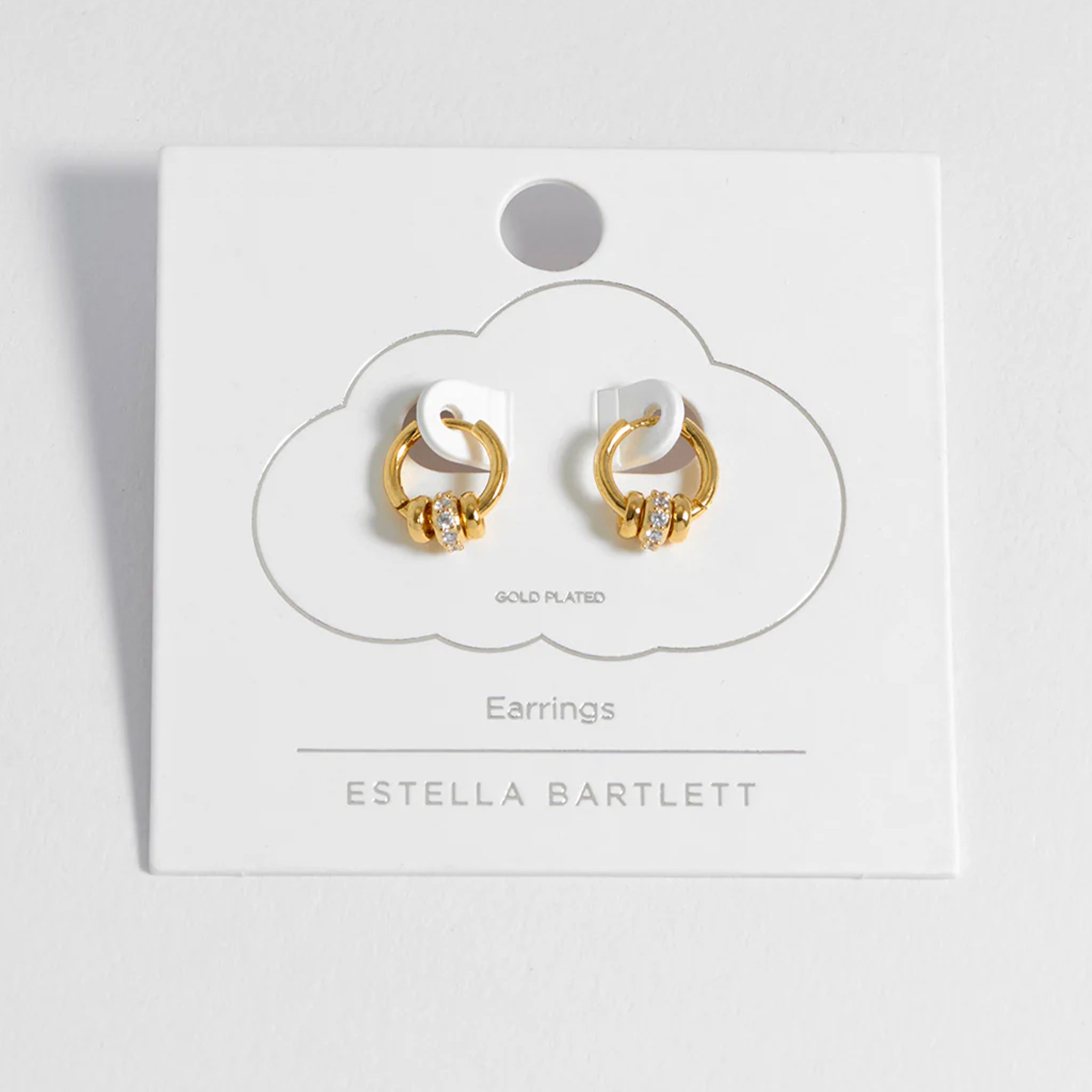 Gold and white hoop earrings on a branded card with Estella Bartlett logo.