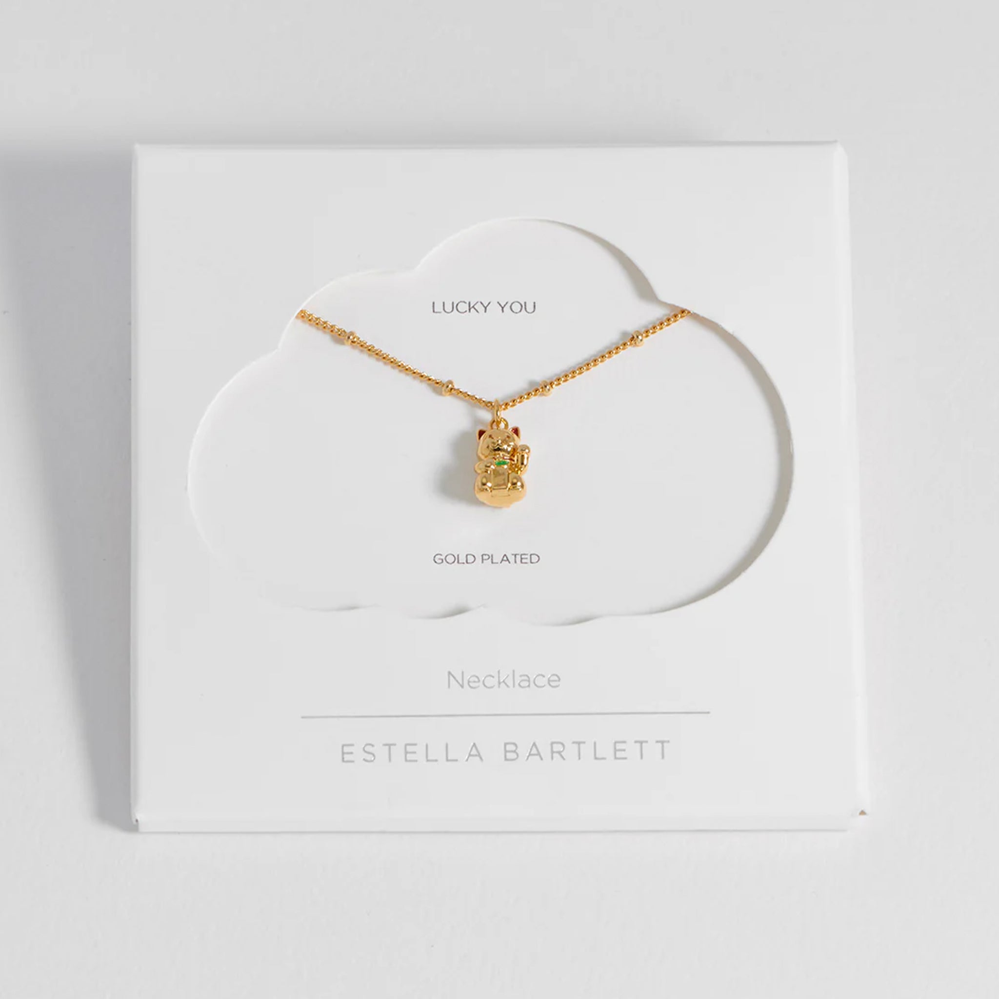 Gold necklace on a white card with 'Estella Bartlett' branding
