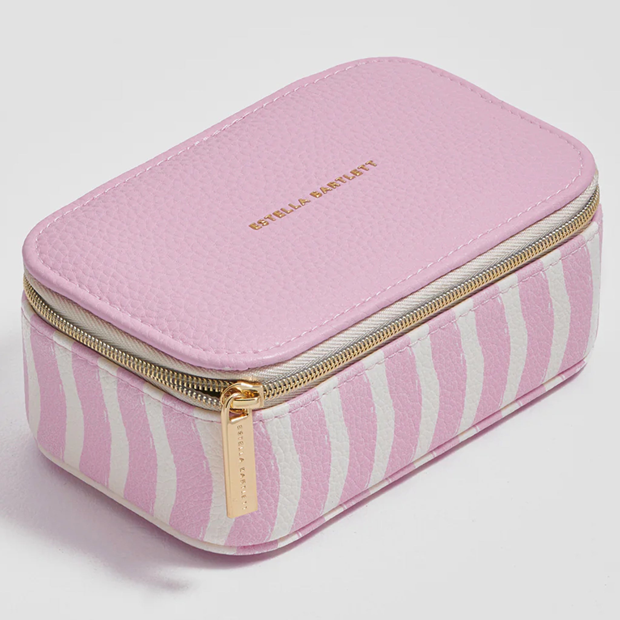 Pink jewelry box with striped pattern and gold zipper on a light gray background