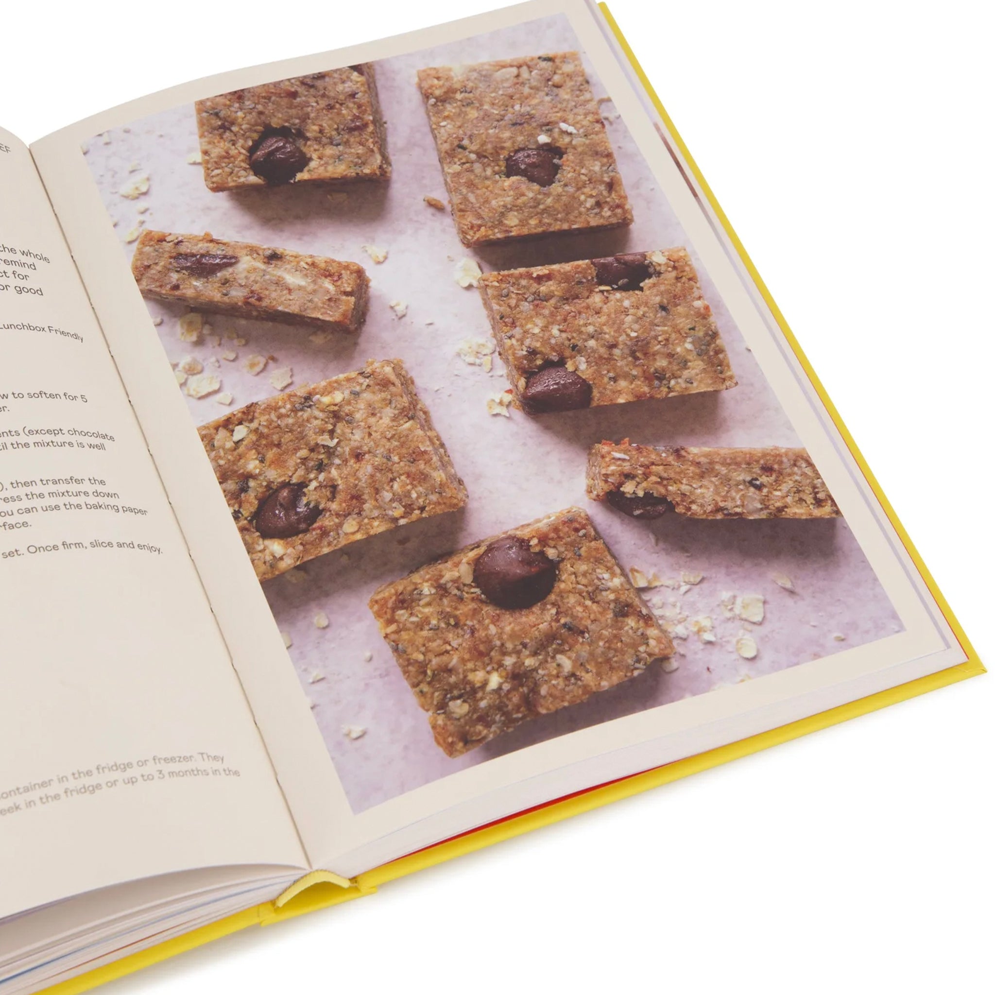 Open book with a recipe for chocolate chip cookie bars on a white background