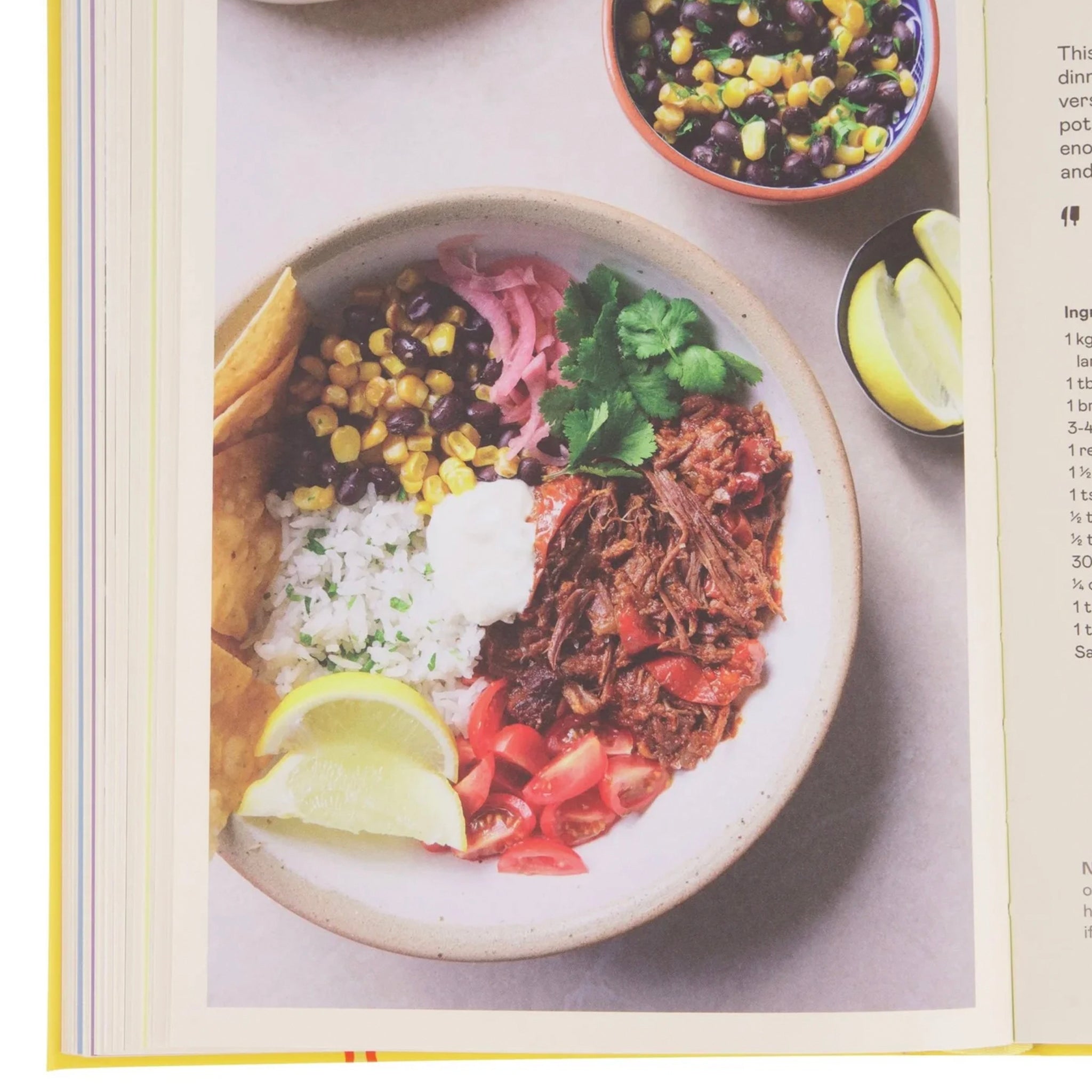 Colorful dish with rice, beans, and vegetables on a plate, surrounded by additional ingredients.