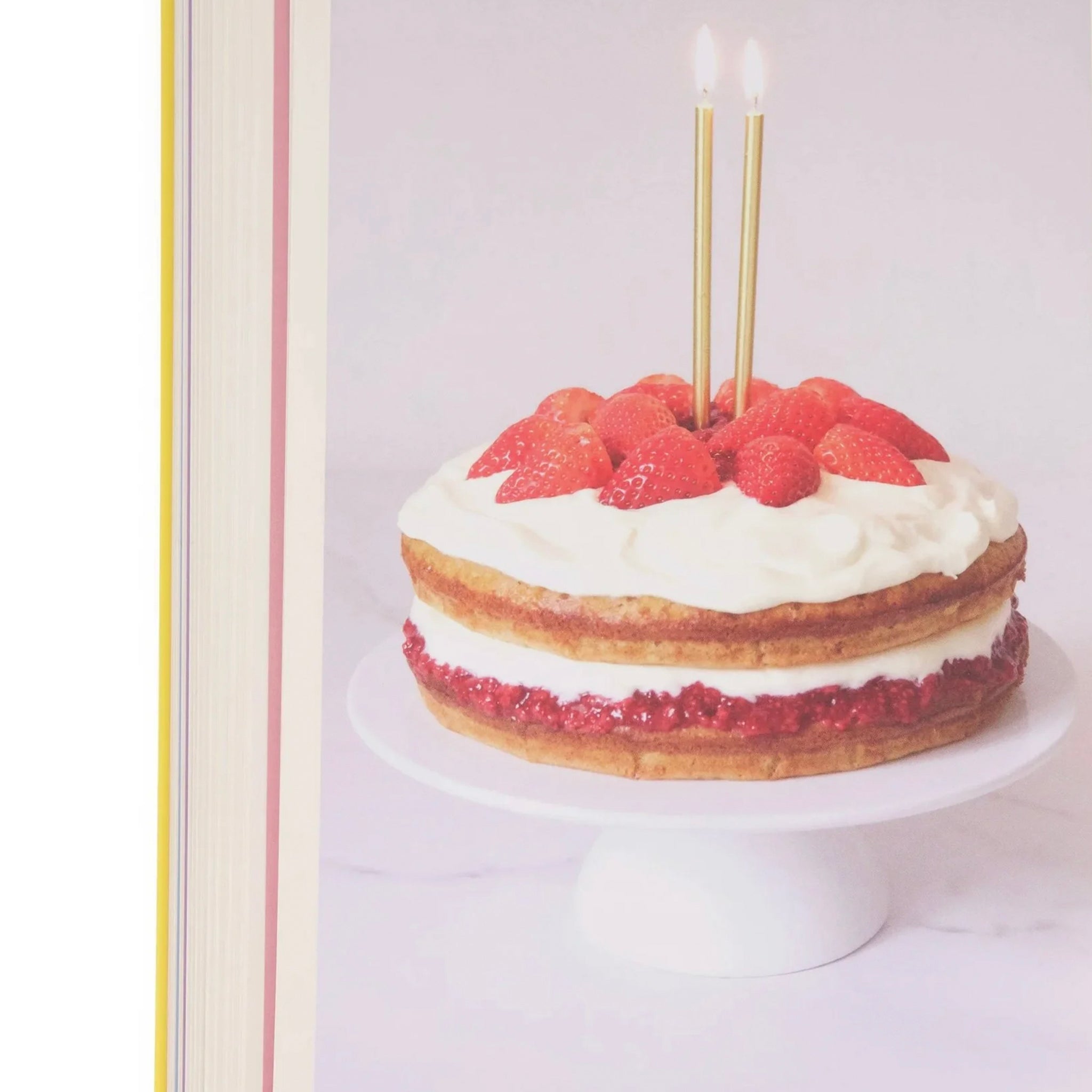 Cake with raspberries and gold candles on a white background